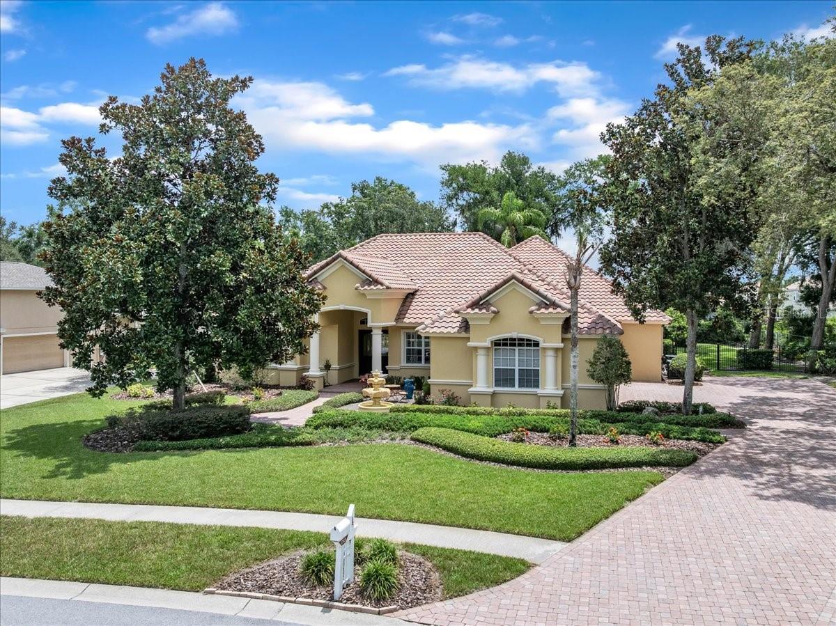 Tile roof, mature trees, and a pavered drive set the tone for luxury!