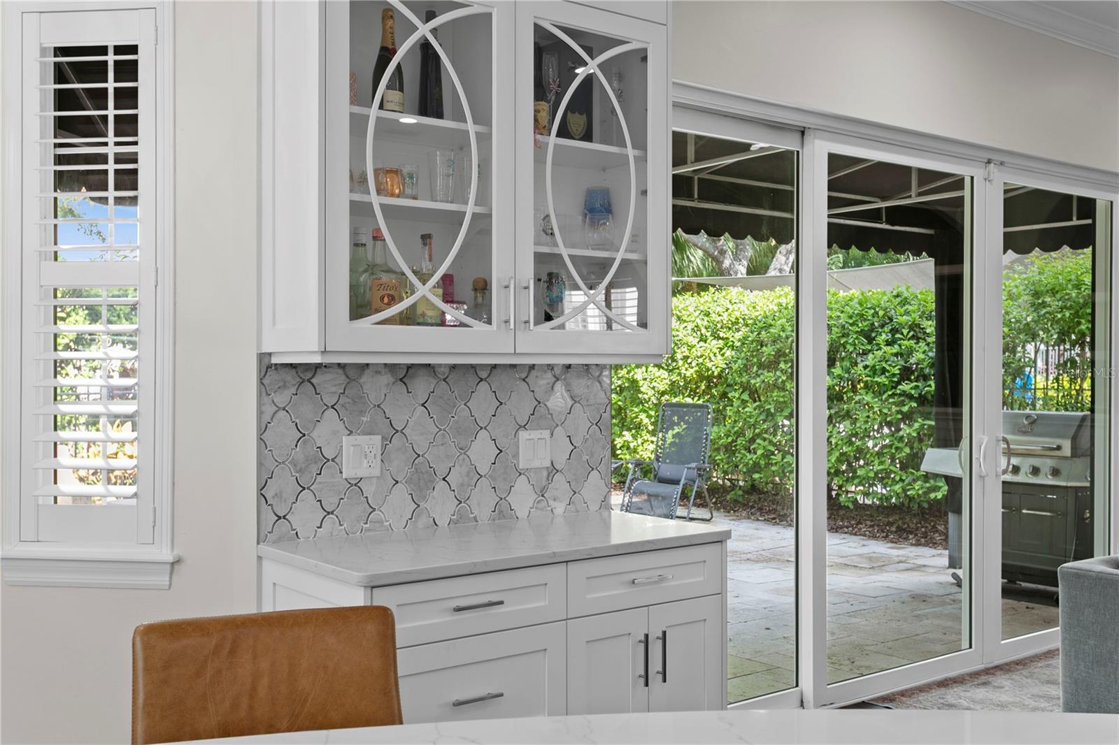 The backyard is accessible from both the kitchen and family room through impact-rated sliding doors.