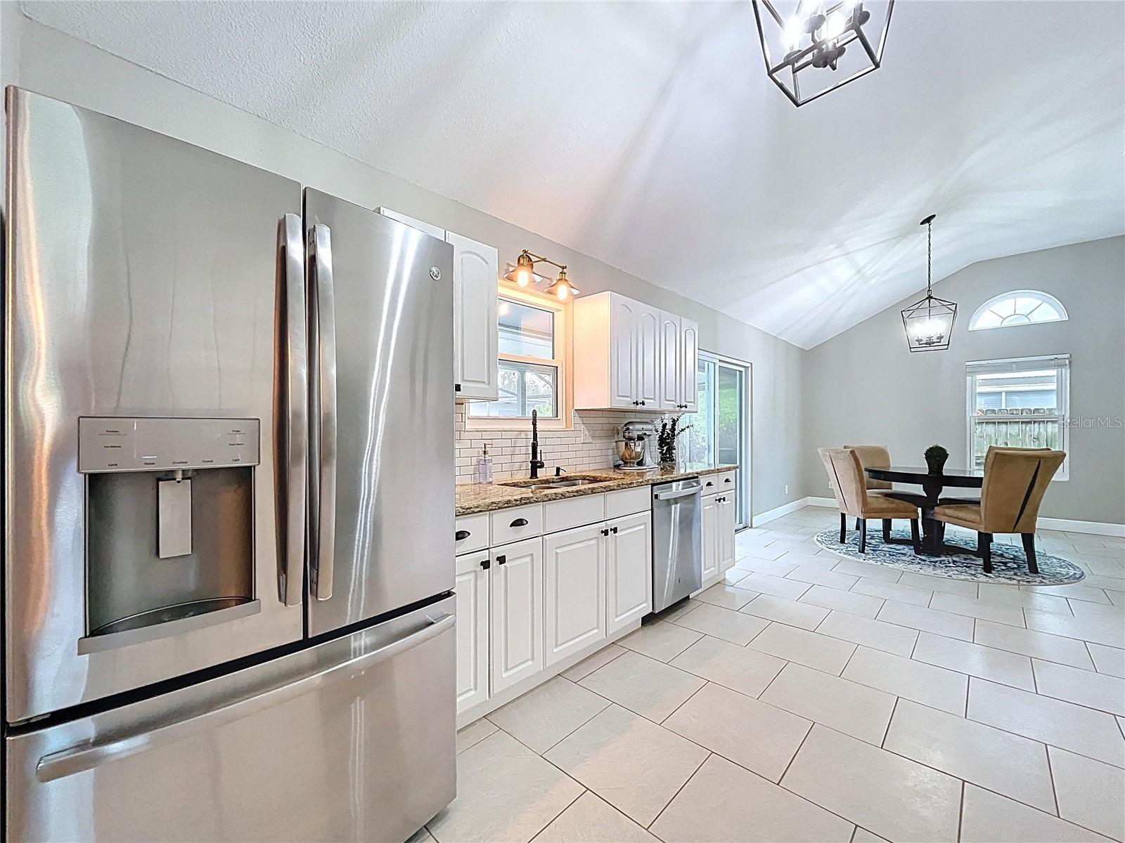 This perspective highlights the open transition from kitchen to the breakfast nook and backyard, enhancing the home’s entertaining potential.