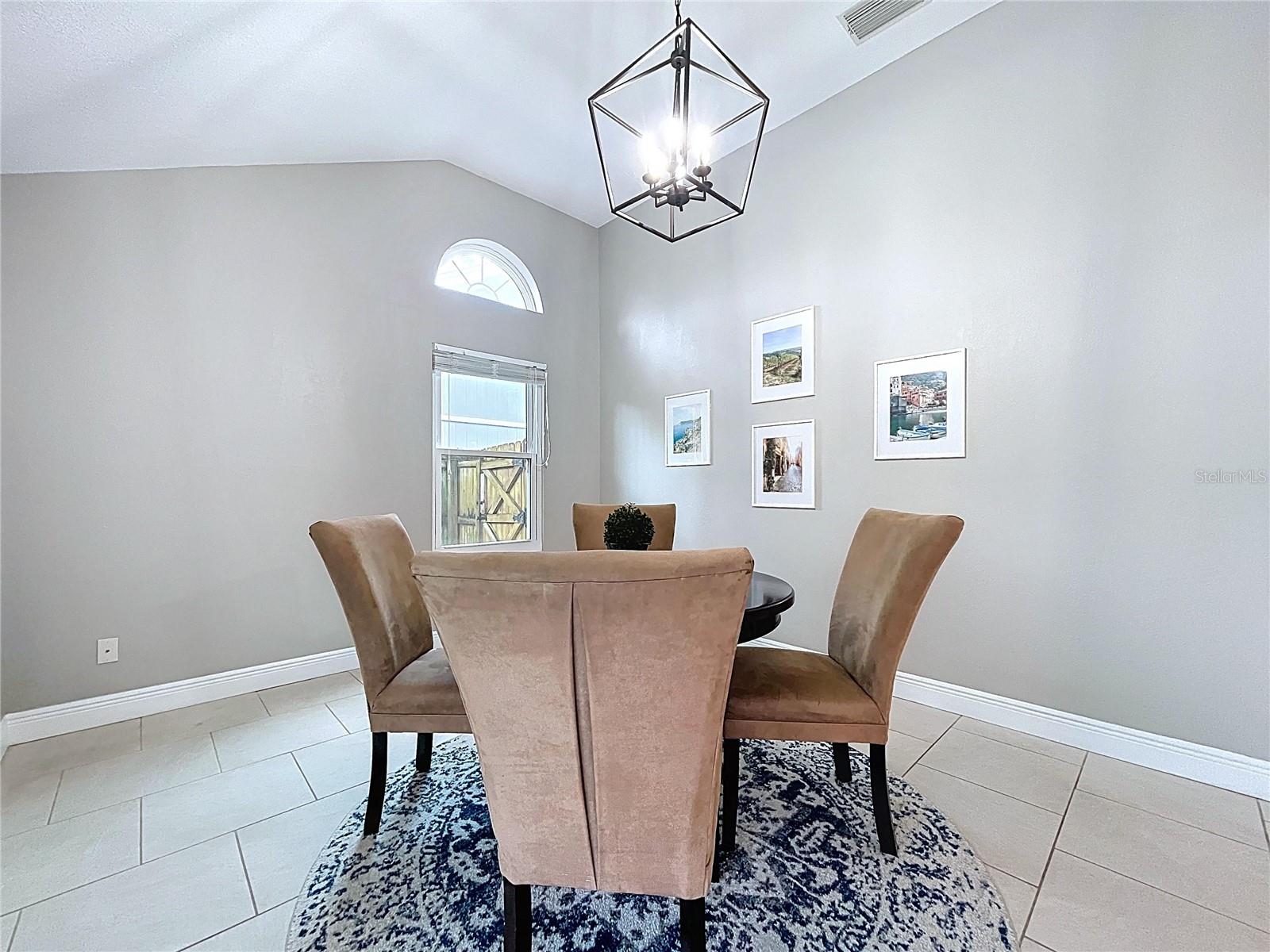 Another view showcasing sliding glass doors to the patio and the open layout that ties into the kitchen.