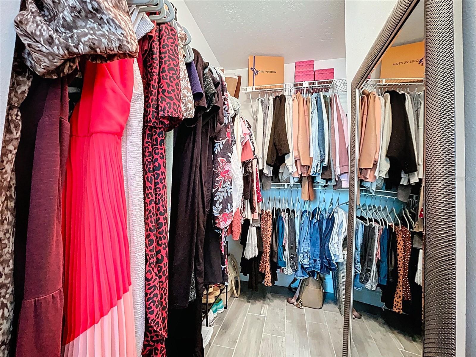 Generously sized walk-in closet with custom shelving and room for seasonal storage, offering both functionality and style.