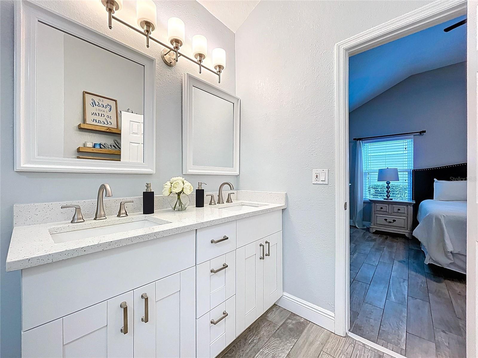 Updated primary bath with a dual-sink vanity, quartz countertops, and contemporary lighting for a polished, spa-like feel.
