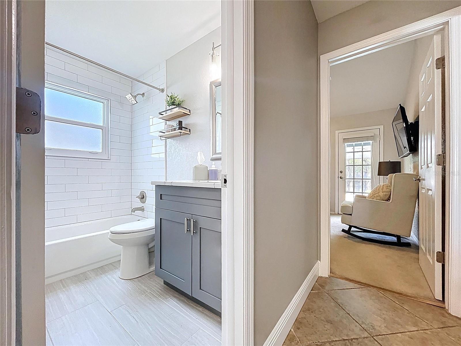 The hall bath features a modern vanity with quartz countertop, updated lighting, and a subway-tiled shower/tub combo for a clean, fresh look.