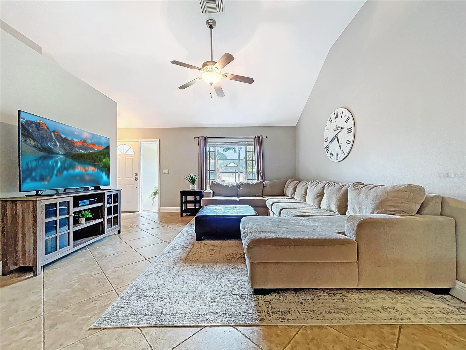 Ample seating and clean sight lines make this the perfect gathering space, complete with a ceiling fan and plenty of wall space for entertainment or décor.
