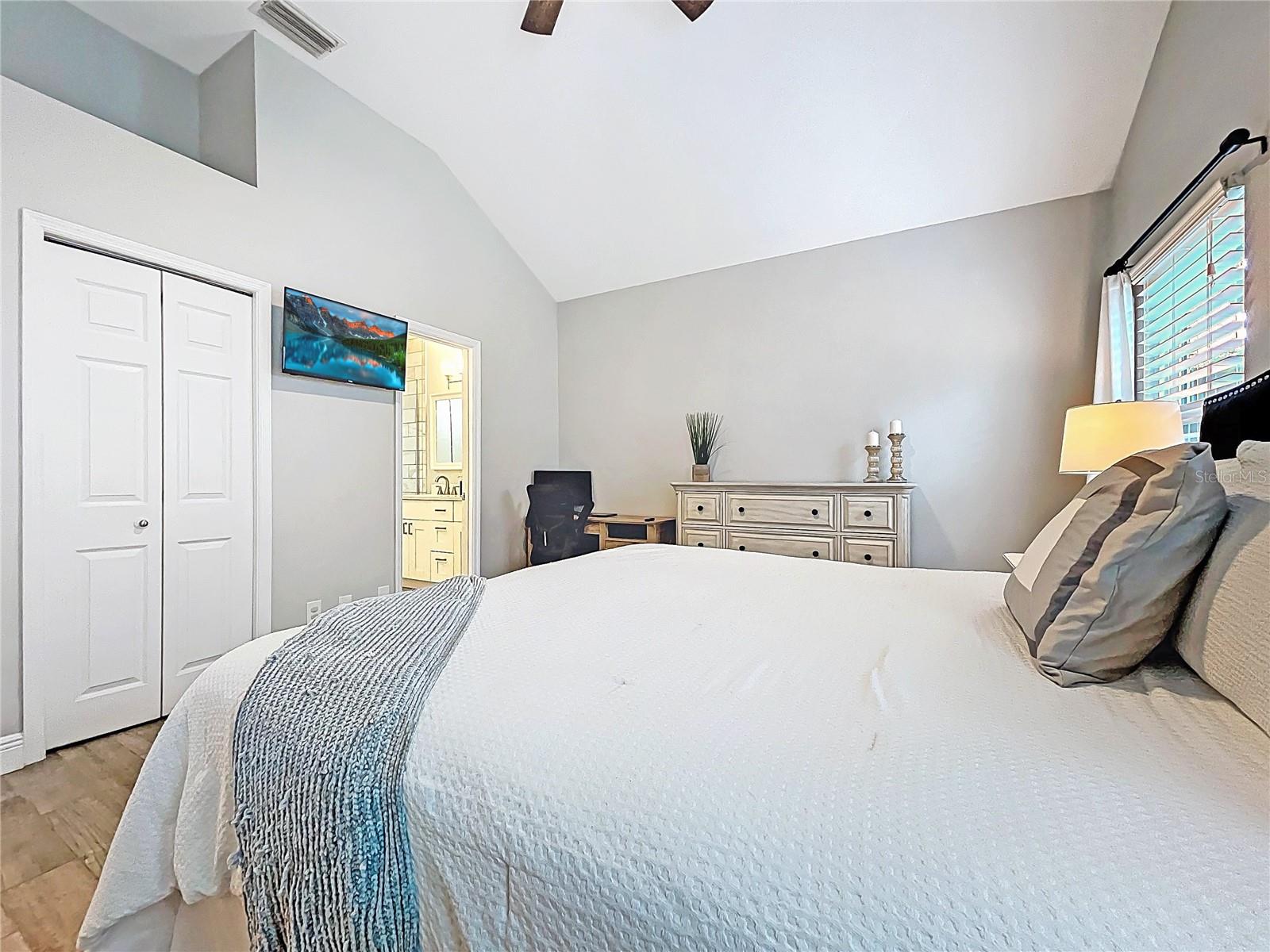 A final view of the primary bedroom highlights a stylish dresser setup and private access to the updated en-suite bath.