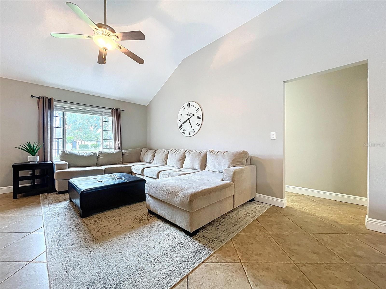 Another angle showcasing the seamless flow between the living space and adjacent areas, complemented by a ceiling fan and cozy layout.