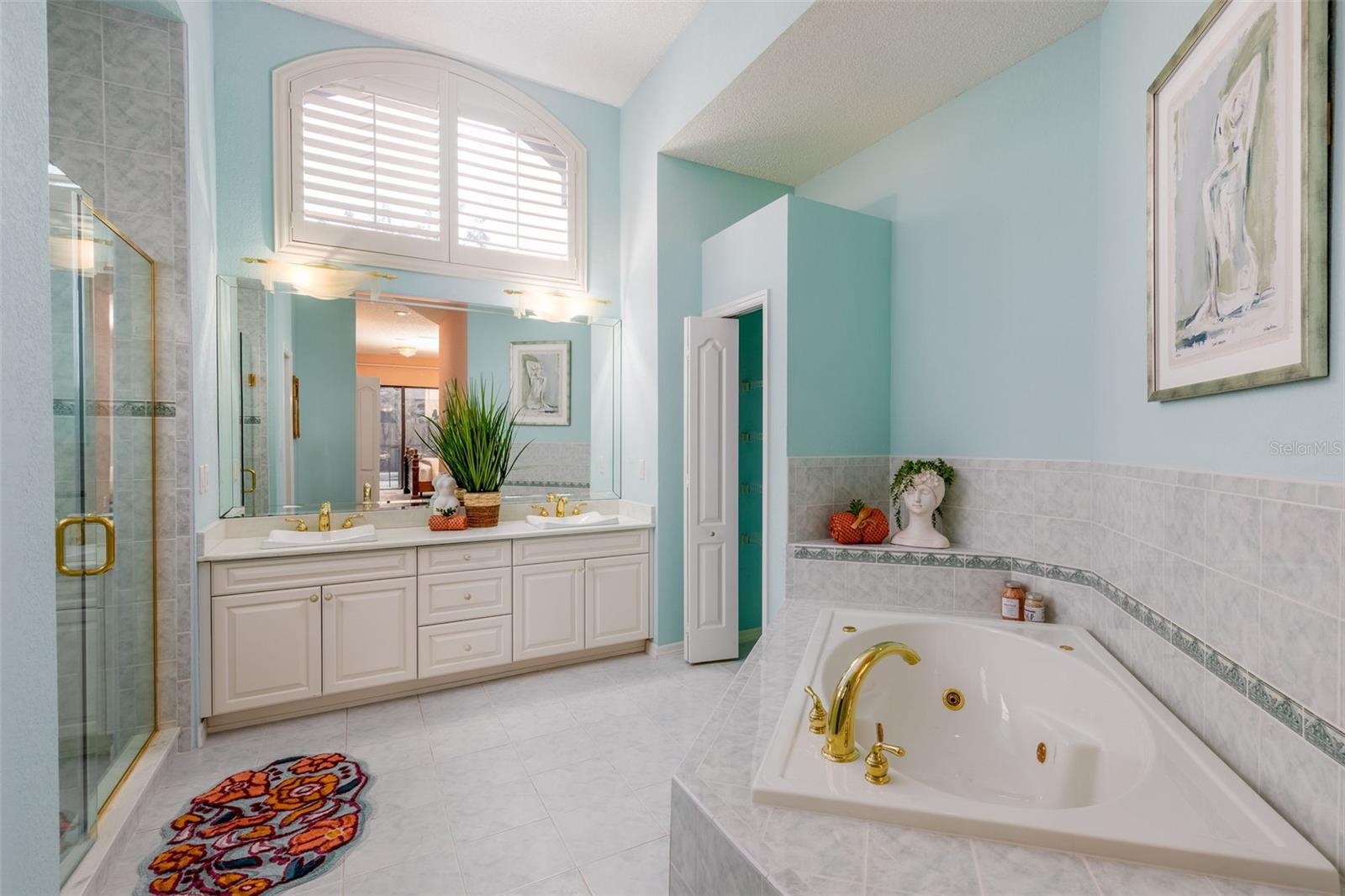 En-Suite Bathroom in Primary Bedroom with Garden Tub, Walk-In Shower, Dual Sinks, Plantation Shutters and Linen Closet