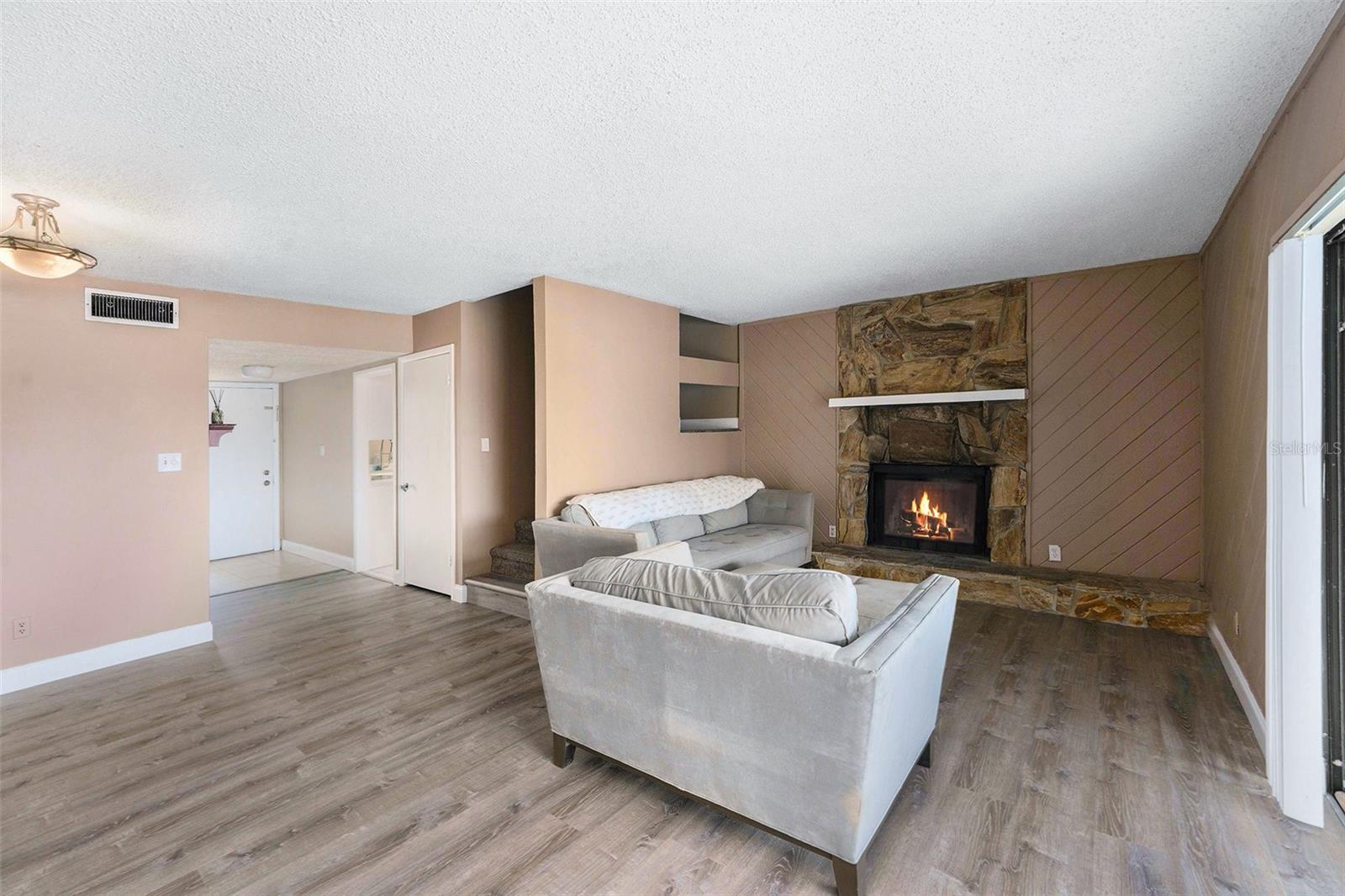 Living room with view of dining area to the left. Stairway, under stair storage area, entry to the kitchen and front door. Across from the kitchen is the guest bath and the laundry/utility room.