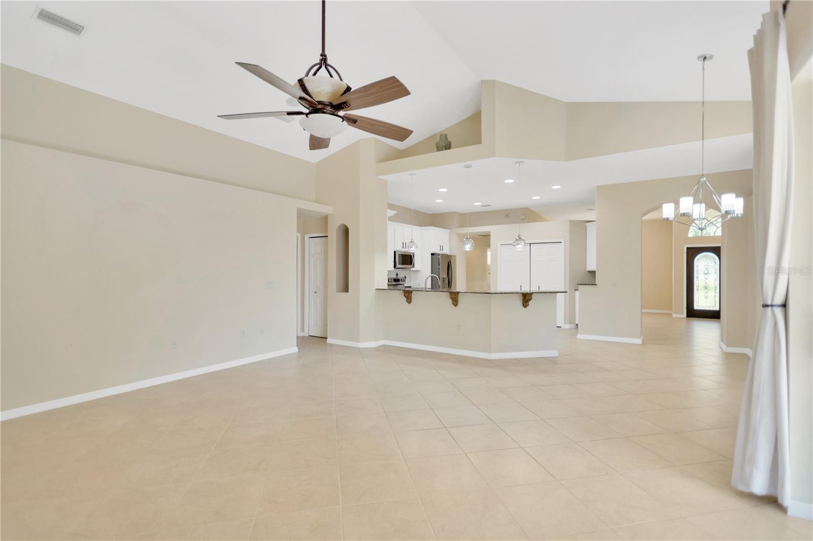 Looking back from the family room into the kitchen and to the front door.