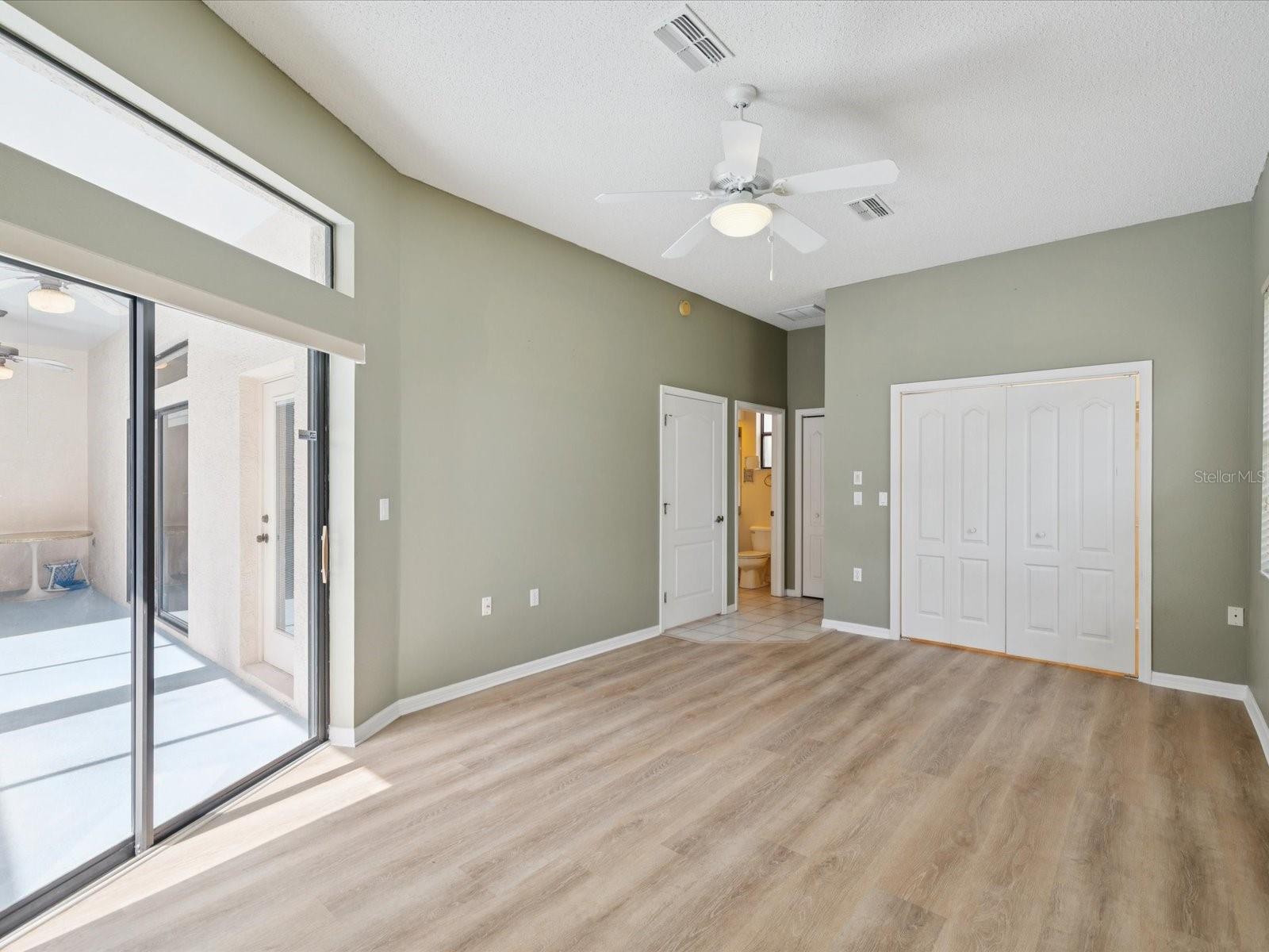 primary bedroom 3 in law side with walk in closet and sliding doors to pool