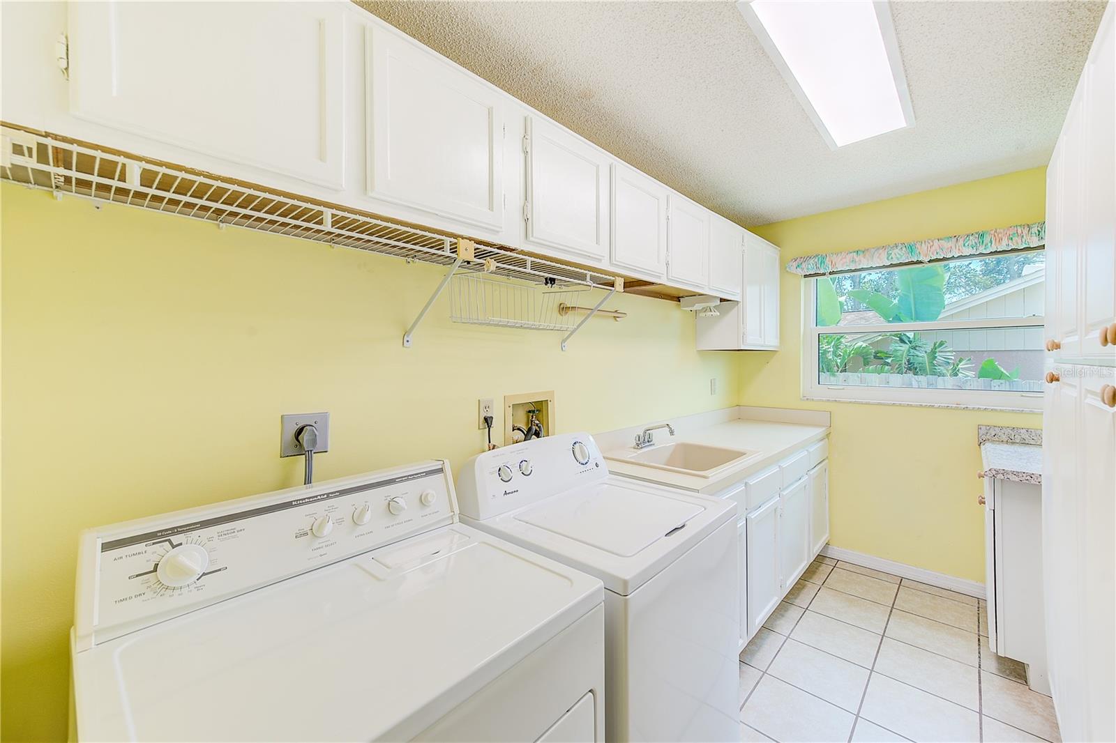 Indoor laundry room with tons of cabinets and storage