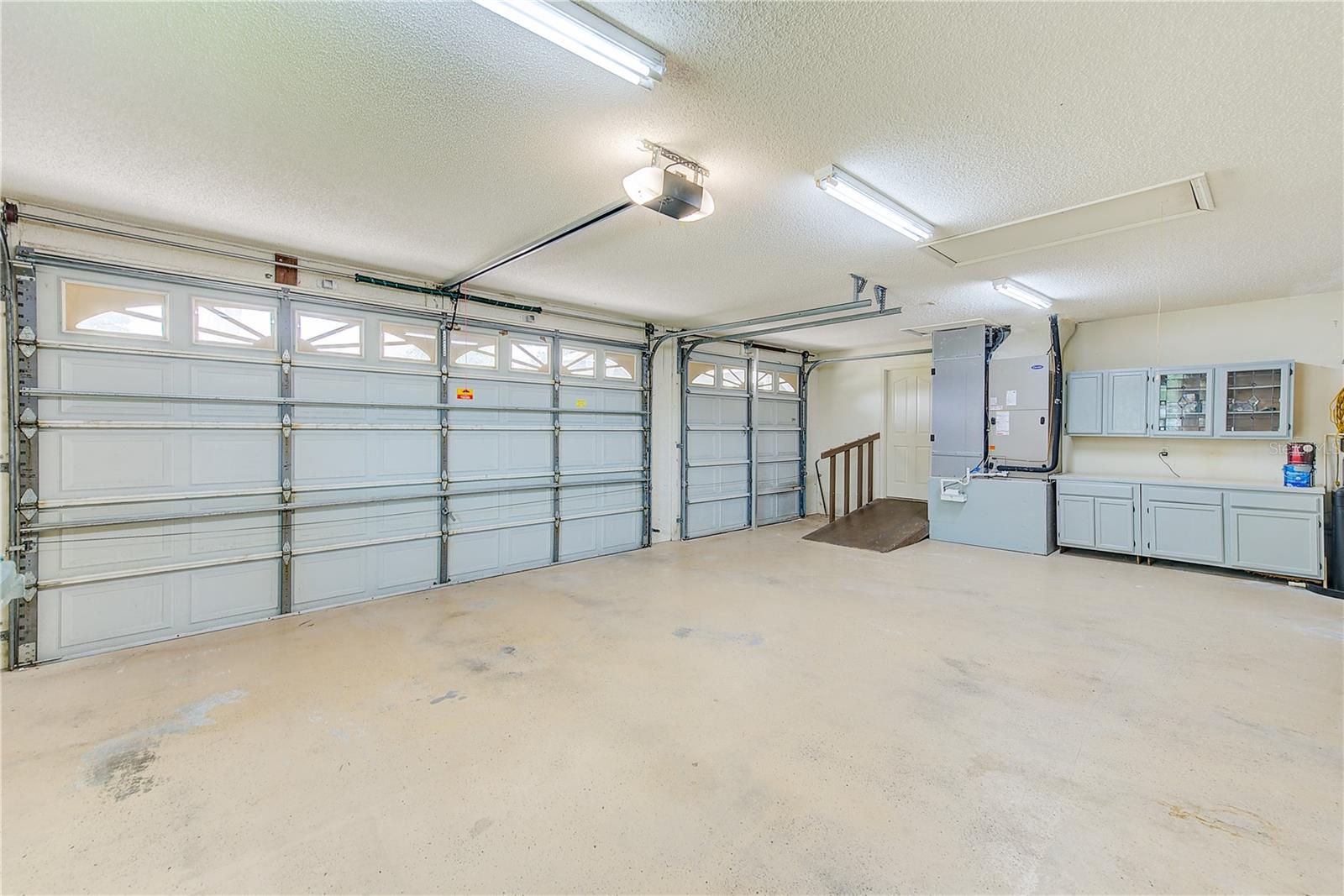 Large 3 car garage with workshop area and cabinets