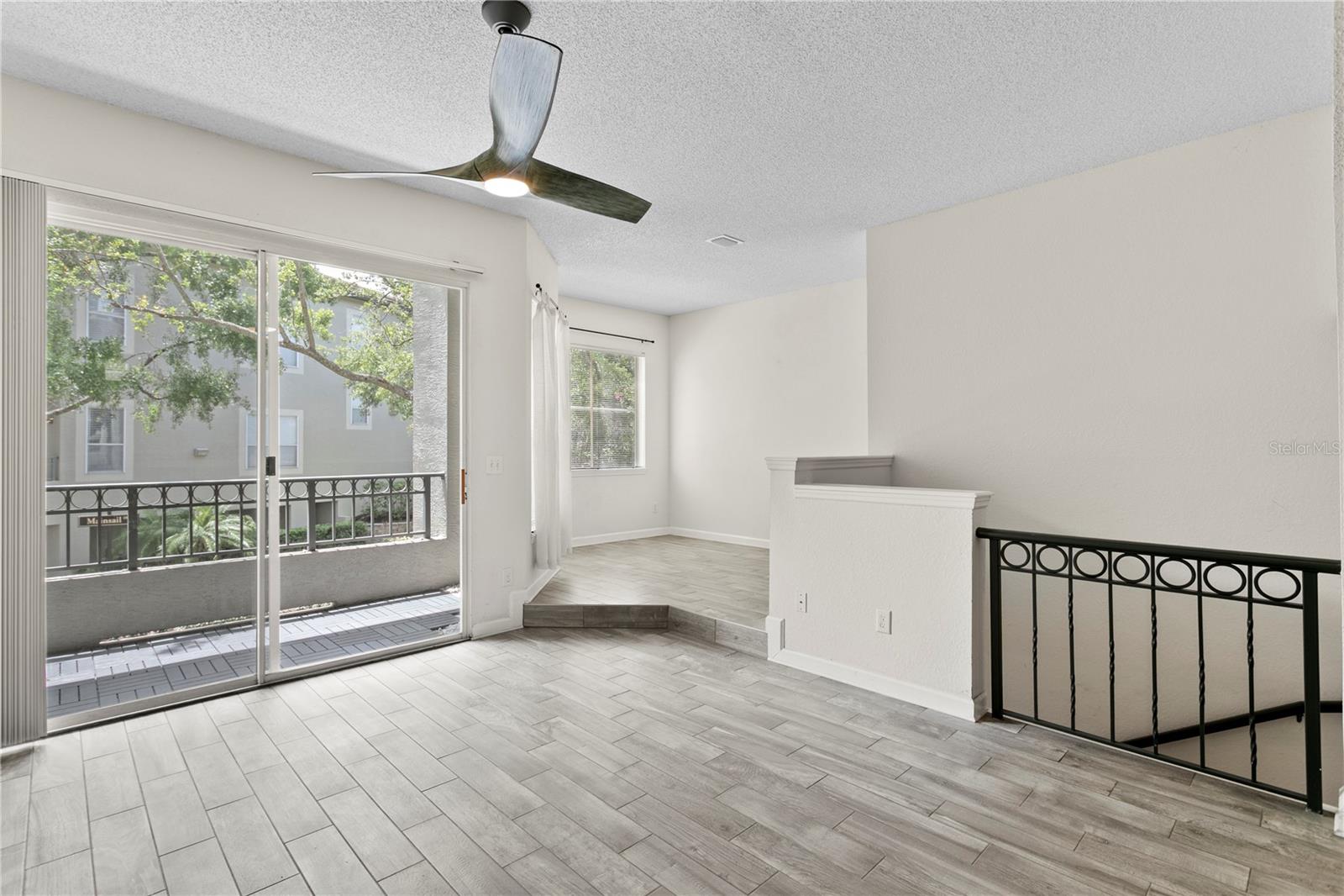 The well-appointed living room offers space for a cozy sofa and is bathed in natural light from the nearby balcony.