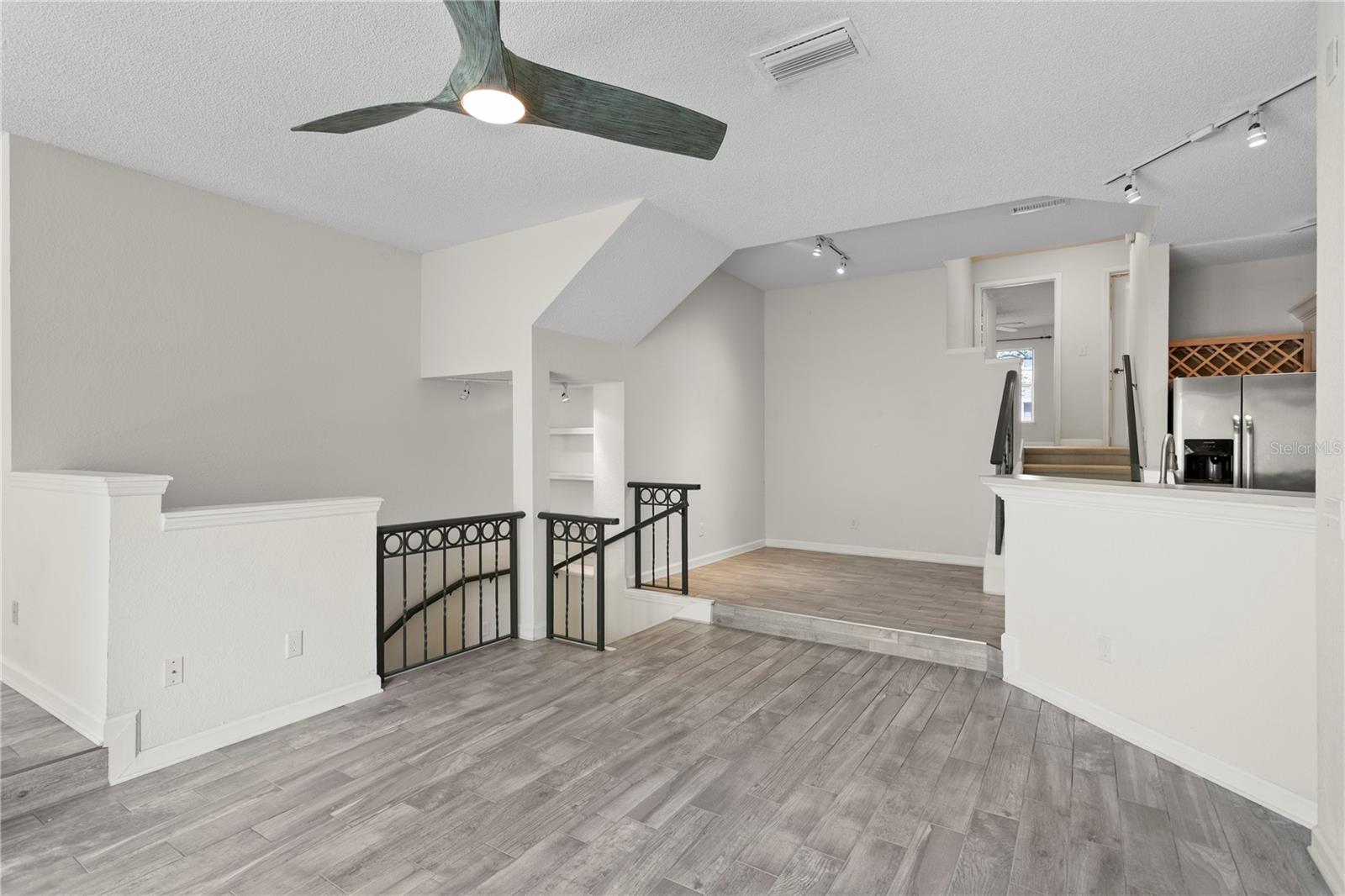 At the top of the stairs, you're welcomed by a bright, open-concept layout featuring the living area, kitchen, dining space, and a versatile flex area.