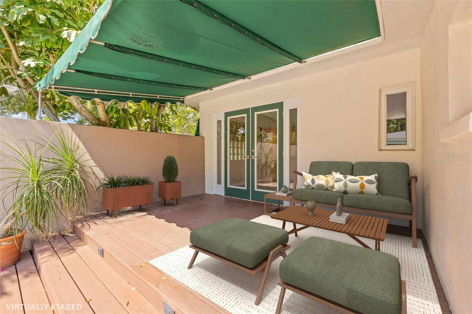 Virtually staged porch with French doors leading into the main dwelling.