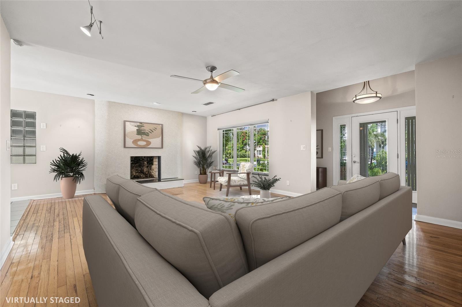 Virtually staged living room of the main dwelling with views of the front door and foyer.