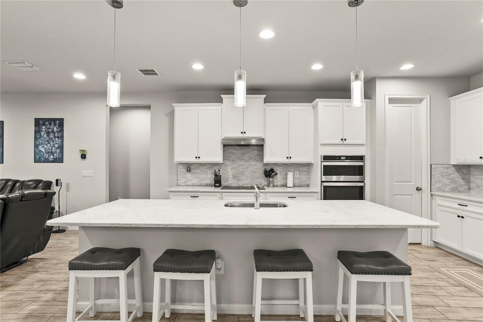 Kitchen view looking at the cooktop and island