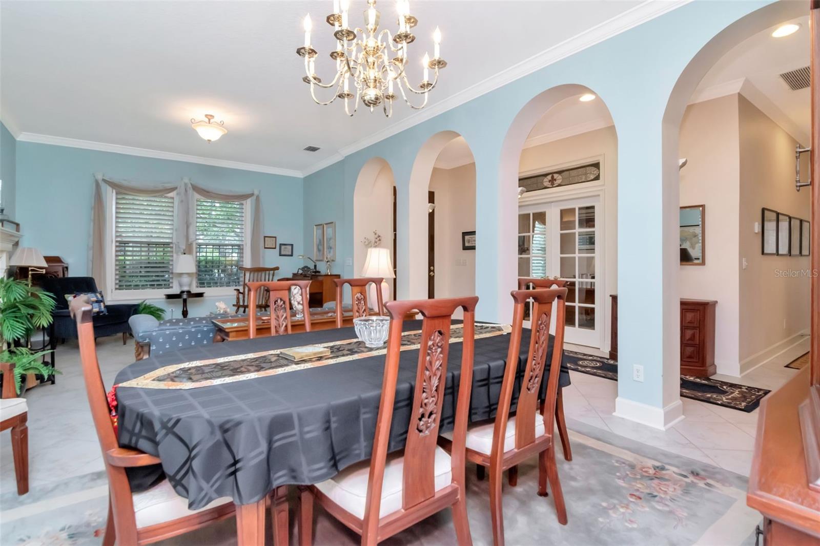 Guests are greeted by a large combination living/dining room with high ceilings and crown molding.
