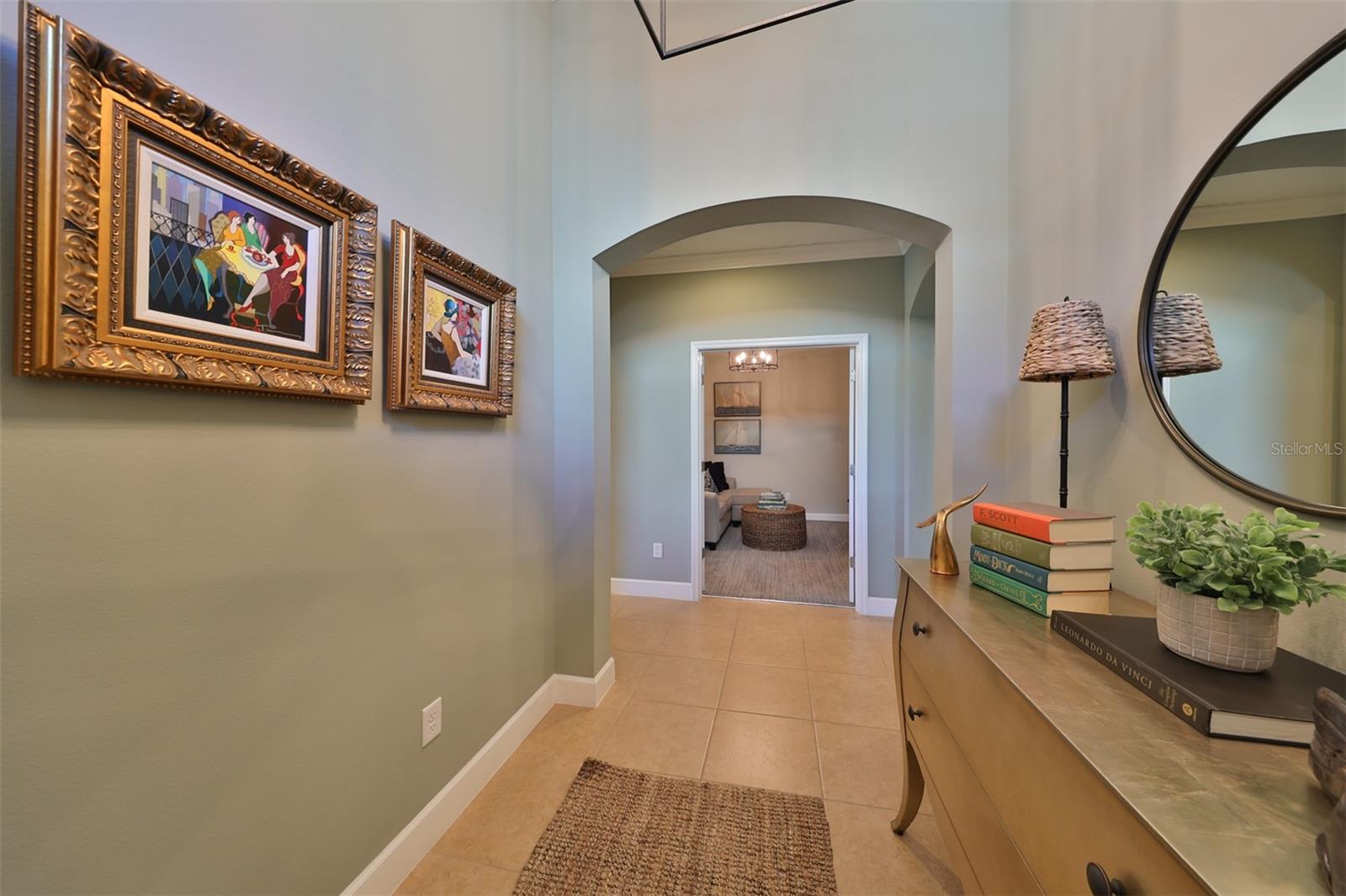 From the foyer entrance you can see the arched doorways that lead to office/den, the with main living area to the left and the second bedroom to the right.