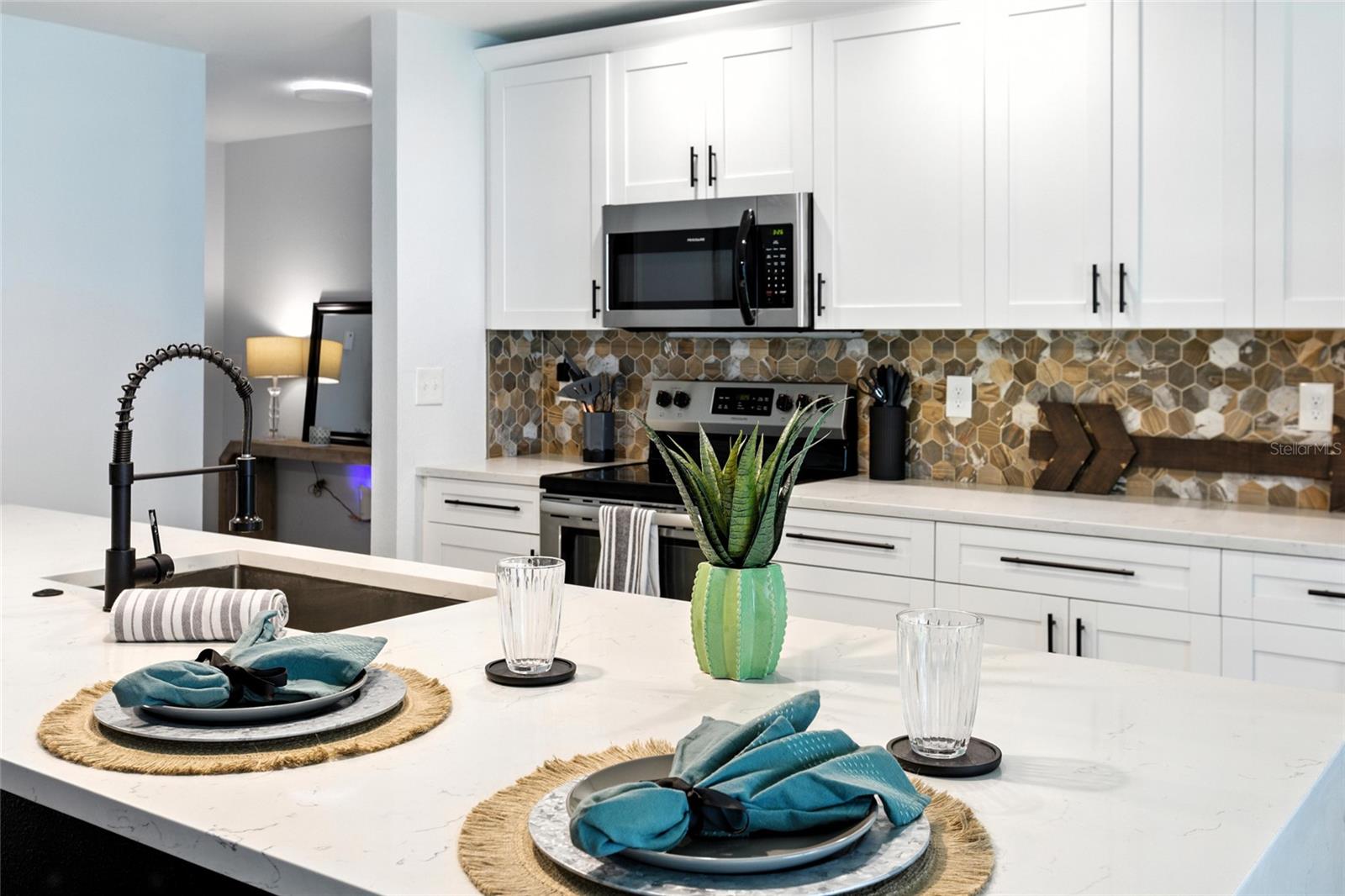 The island accommodates multiple barstools—ideal for everyday dining, morning coffee, or keeping the one cooking company!