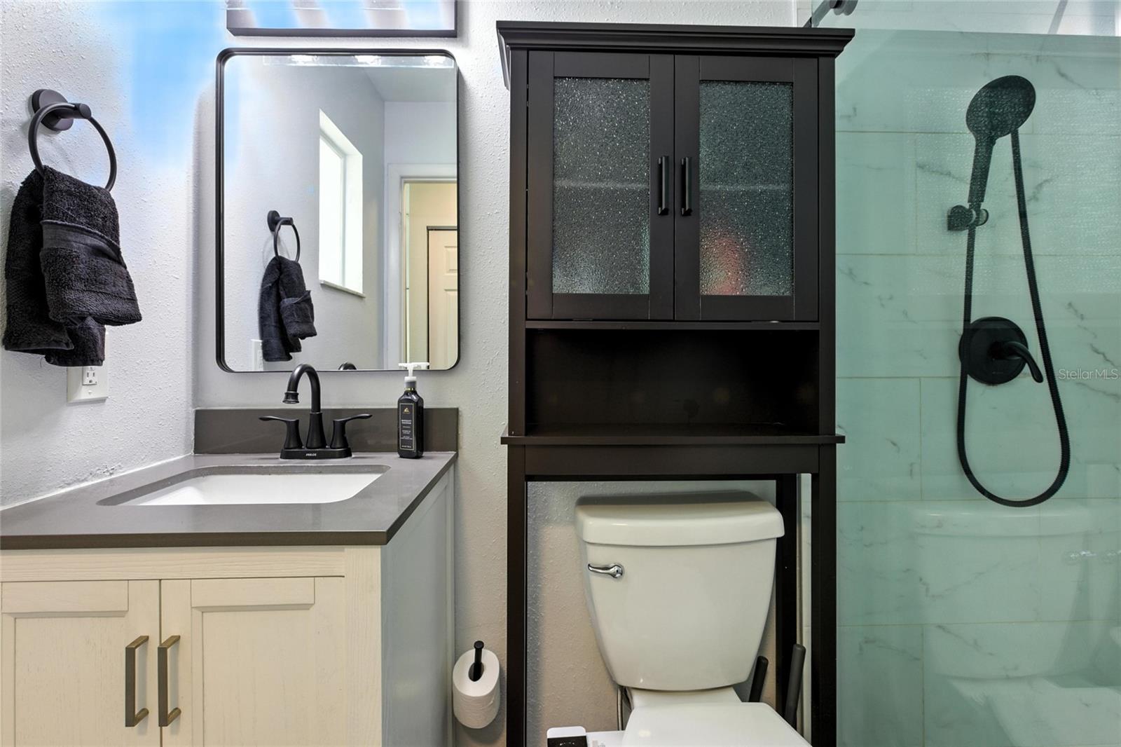 The primary ensuite features quartz countertops, upgraded shower hardware, and a new barn-style glass door—offering a sleek, modern finish with lasting durability