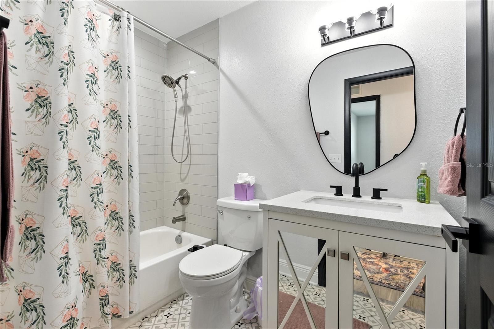 The hall bath checks all the boxes—stylish and functional with updated finishes, quartz counters, and a fun designer tile floor that gives it personality. A full tub and shower combo makes it perfect for guests, kids, or anyone who needs their own space to primp and prep