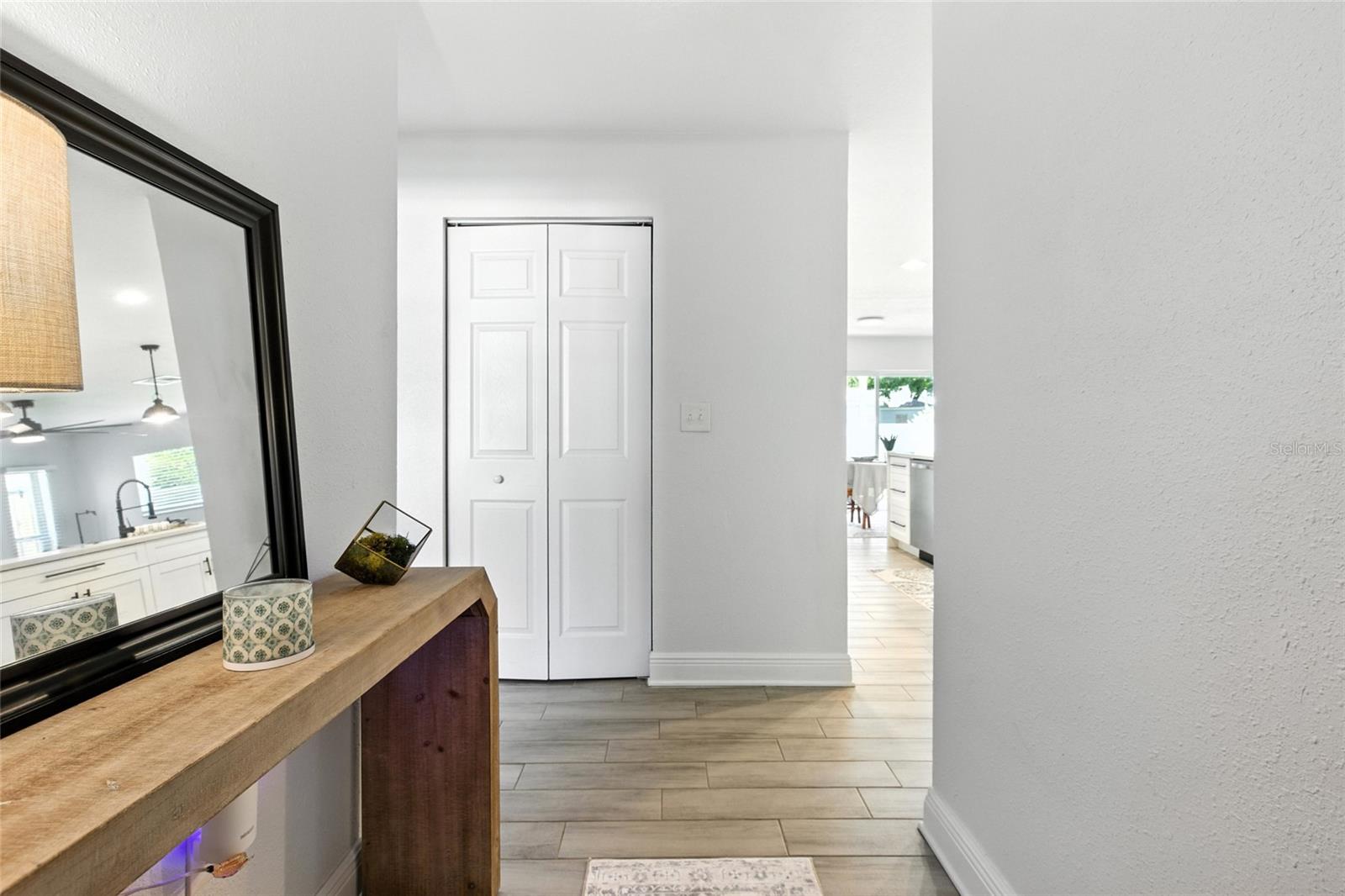 This bright entryway welcomes you with wood-look tile and a peek into the heart of the home