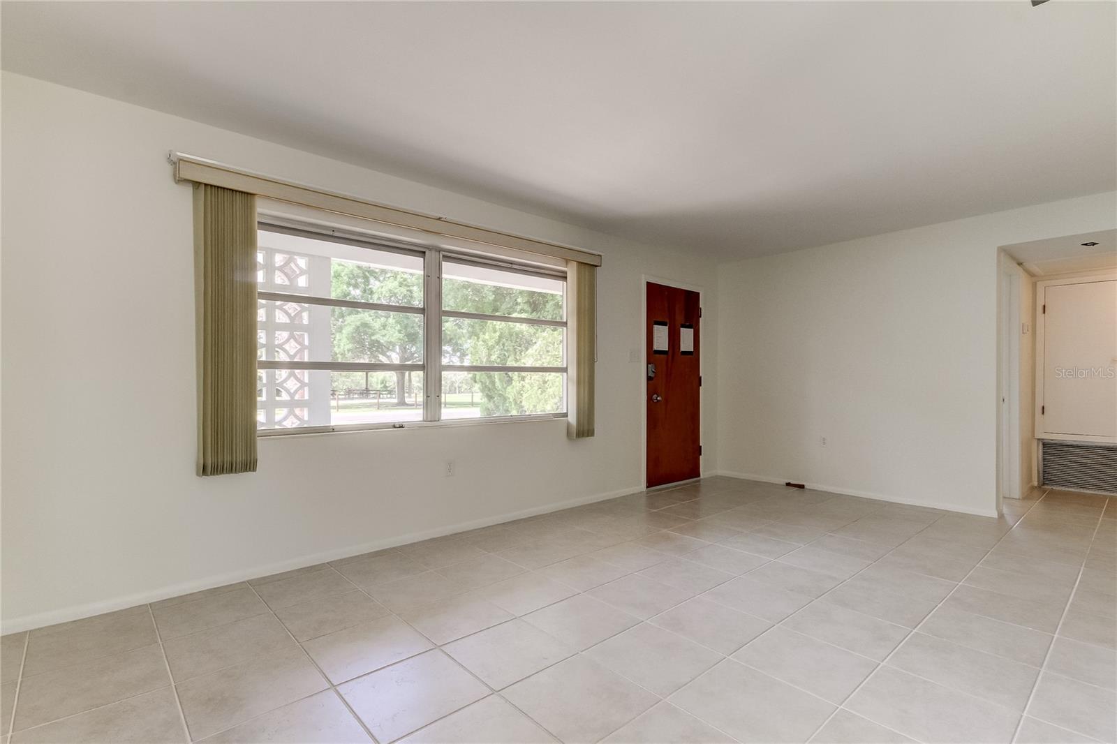 Large front entrance room with expansive windows and views of water.  Ceramic tile floors