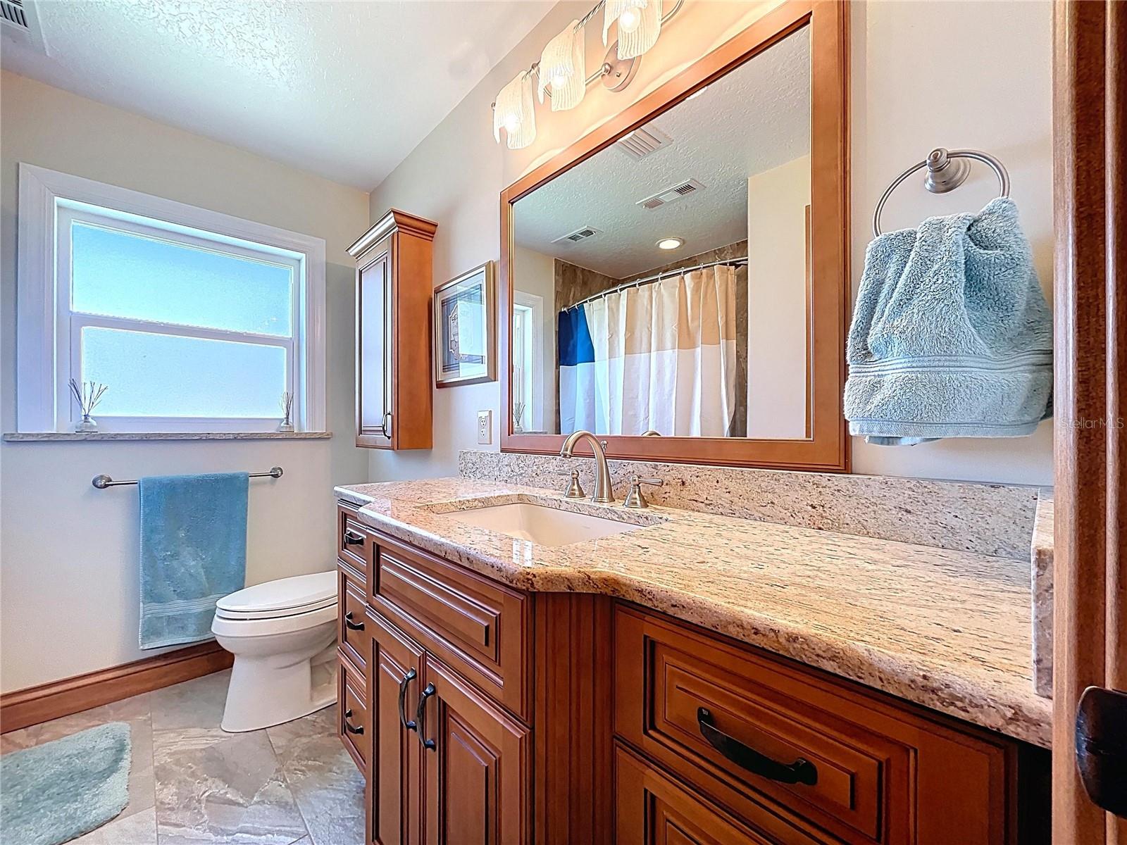 The updated guest bathroom is spotless and offers a shower with tub,