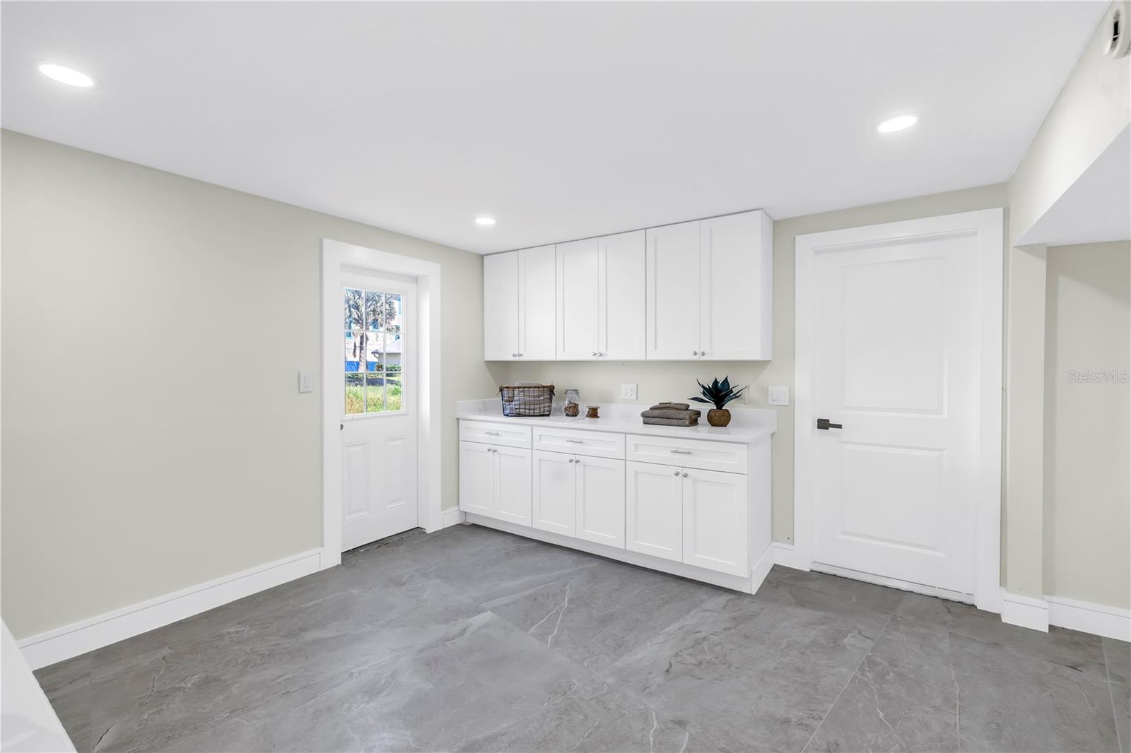 The expansive laundry room provides ample storage, extra pantry space, and a convenient utility sink.