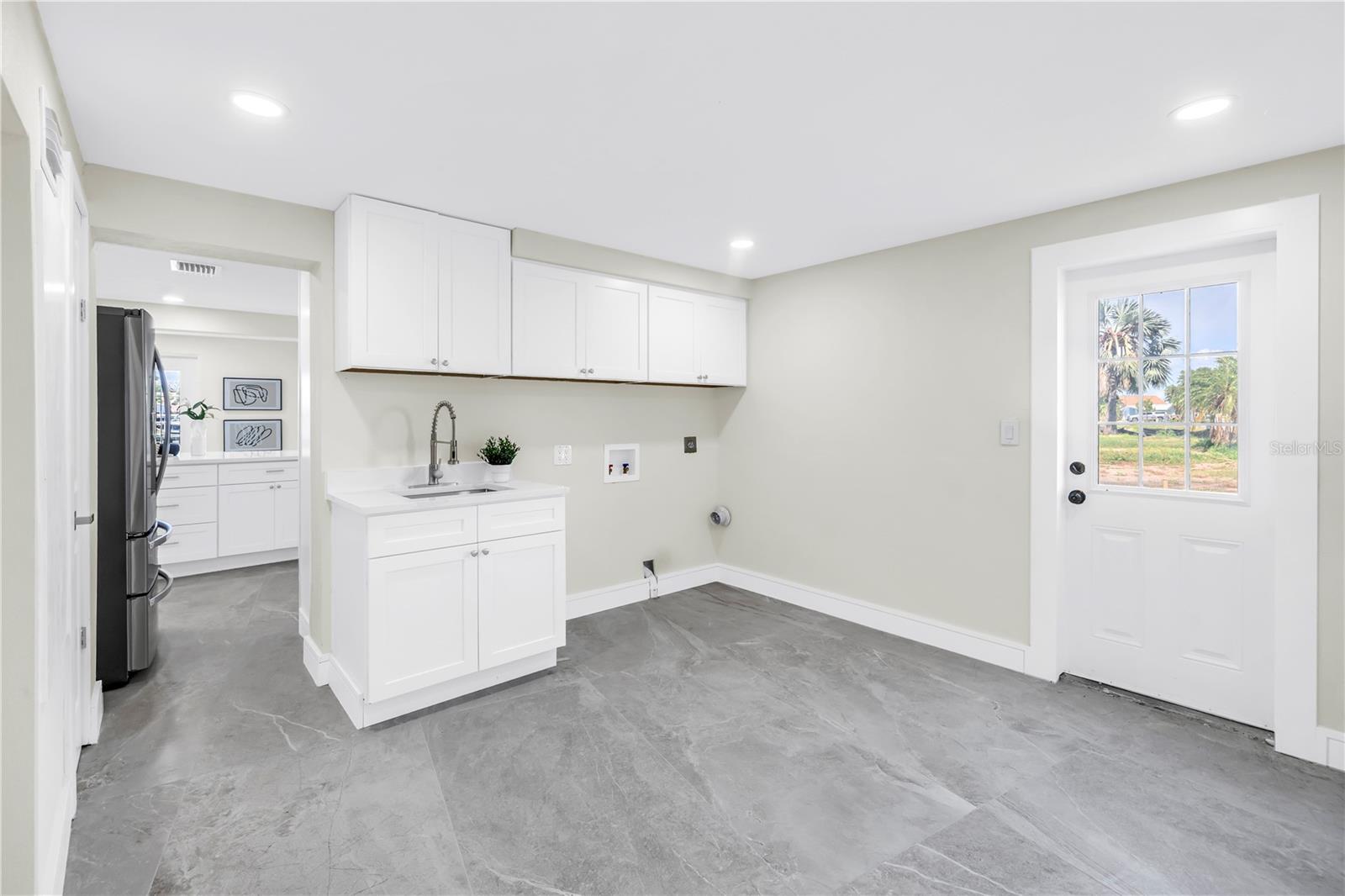 Laundry room offers a side yard door.