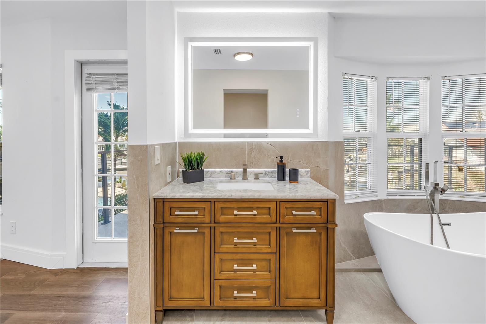 Primary bathroom offers a soaking tub, two vanities and a walk-in rain head shower.