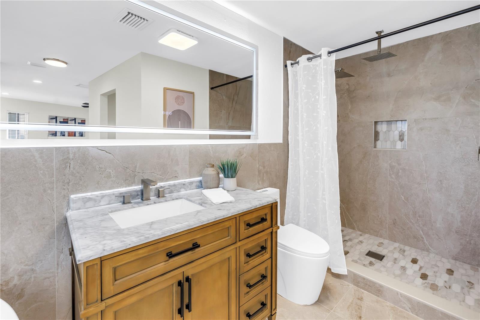 Primary bathroom offers a soaking tub, two vanities and a walk-in rain head shower.