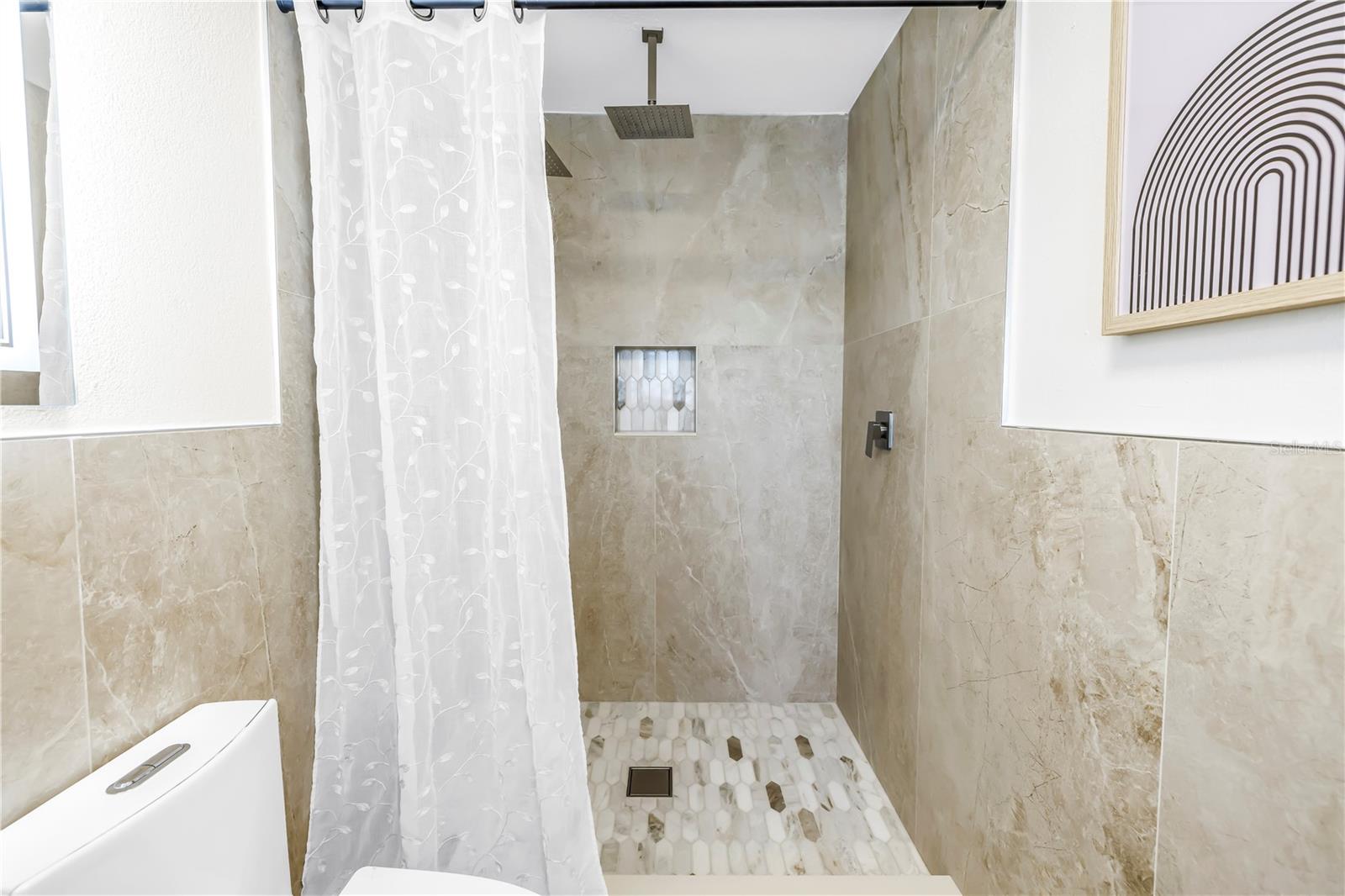 Primary bathroom offers a soaking tub, two vanities and a walk-in rain head shower.