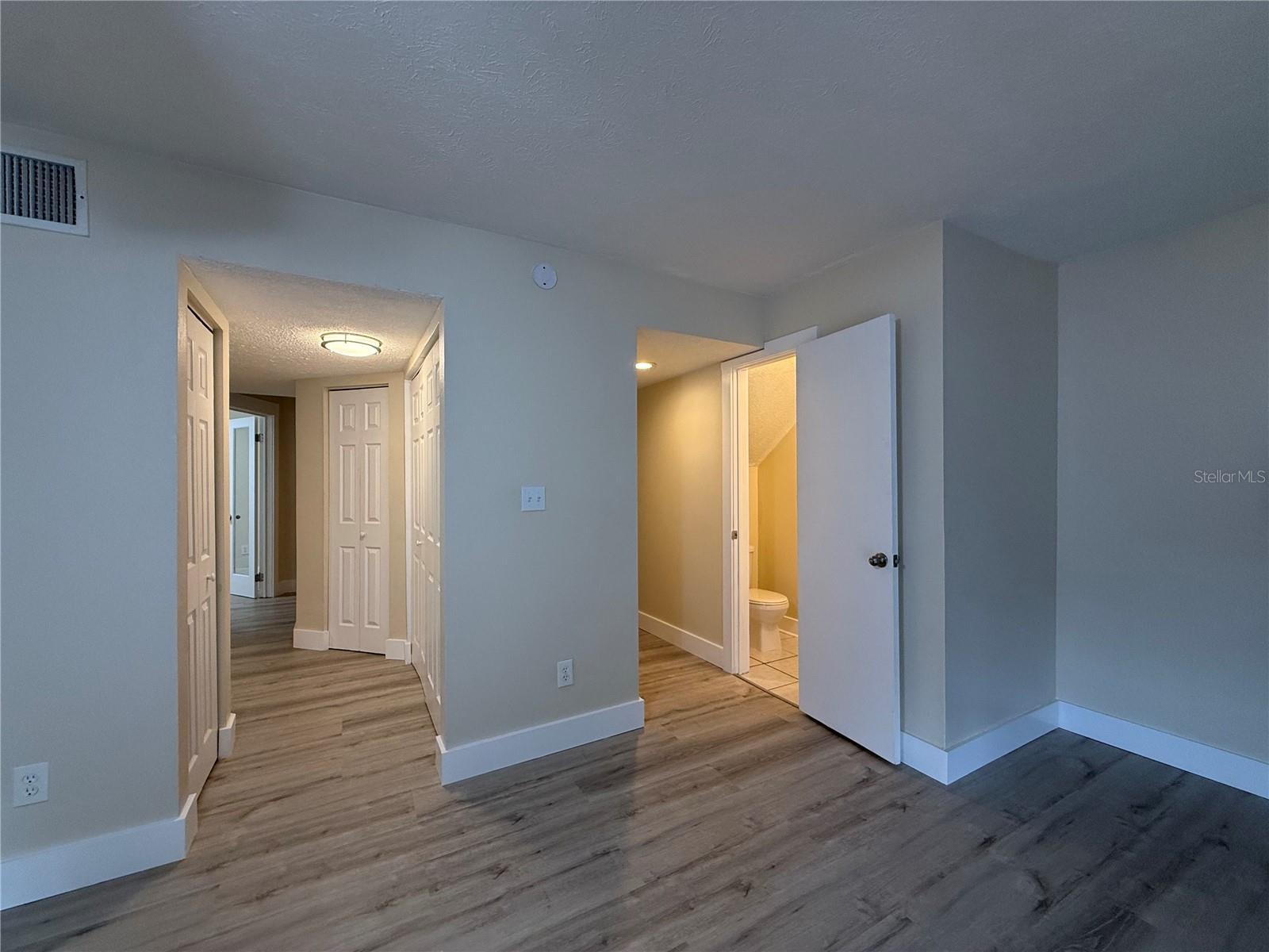Living Room view ro half bath & hallway to den & foyer