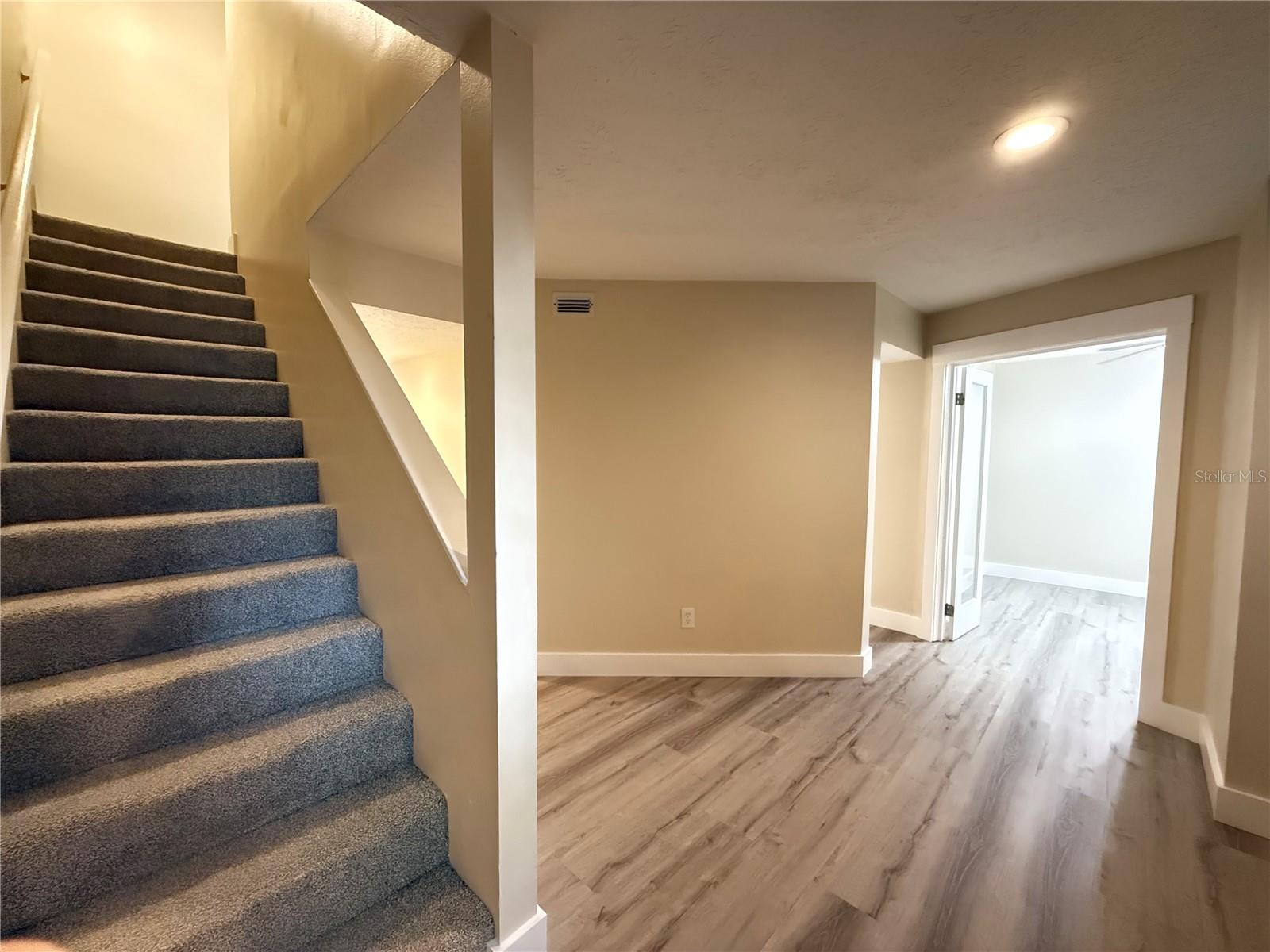 Stairwell, foyer, & entrance to den