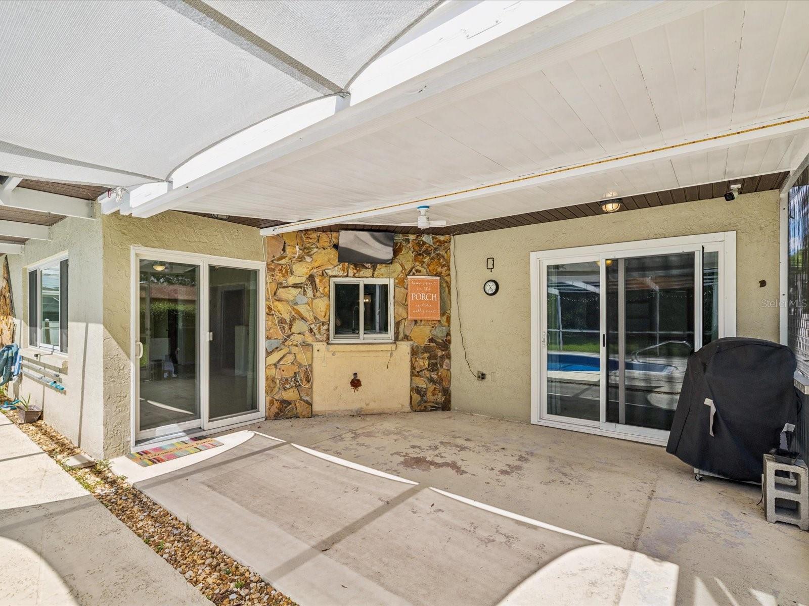 Covered outdoor dining area with plenty of shade and stone detailed pass through window make entertaining a breeze!