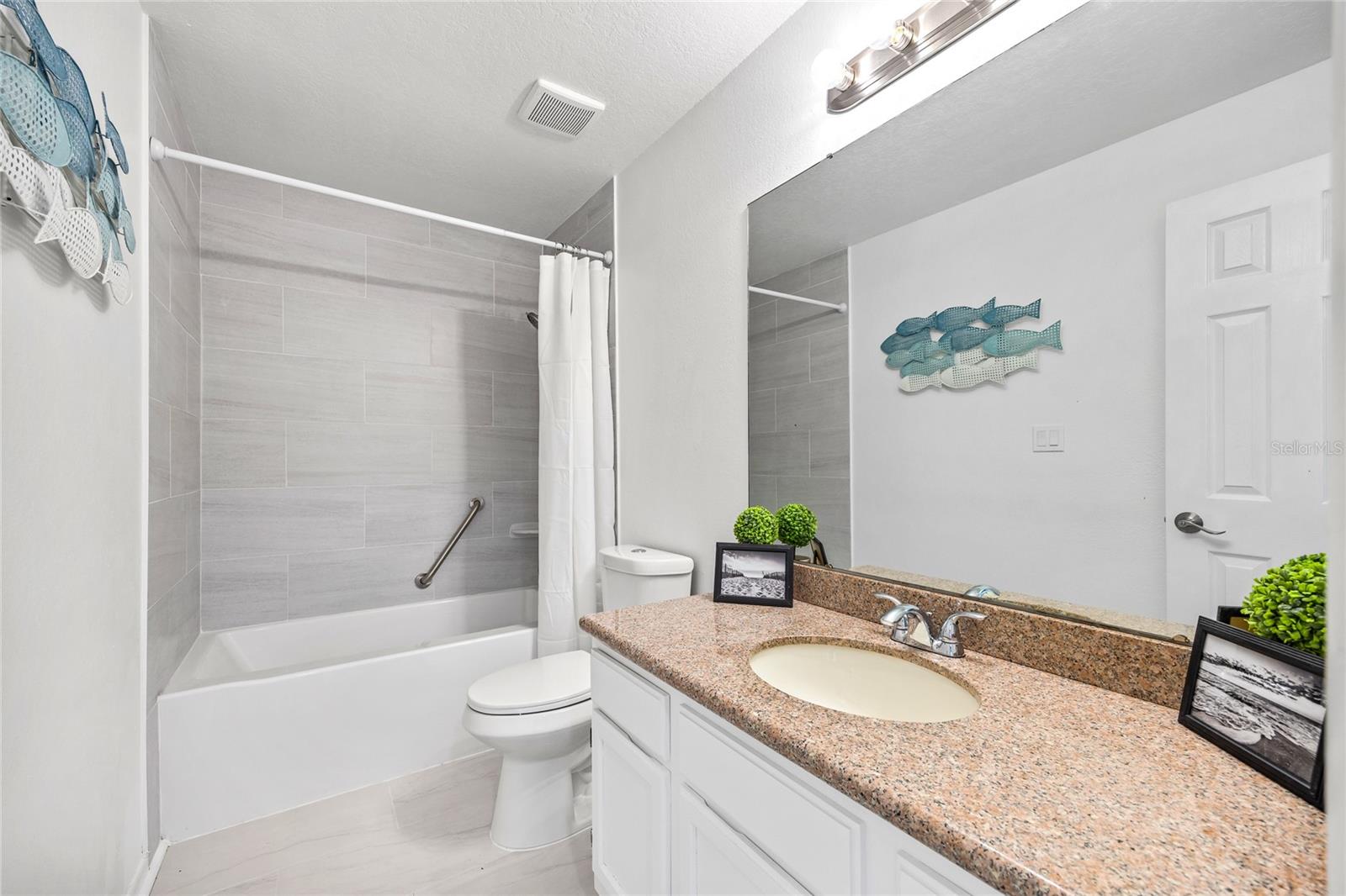 Guest Bathroom with beautiful tiled shower/tub combo and large single sink vanity.
