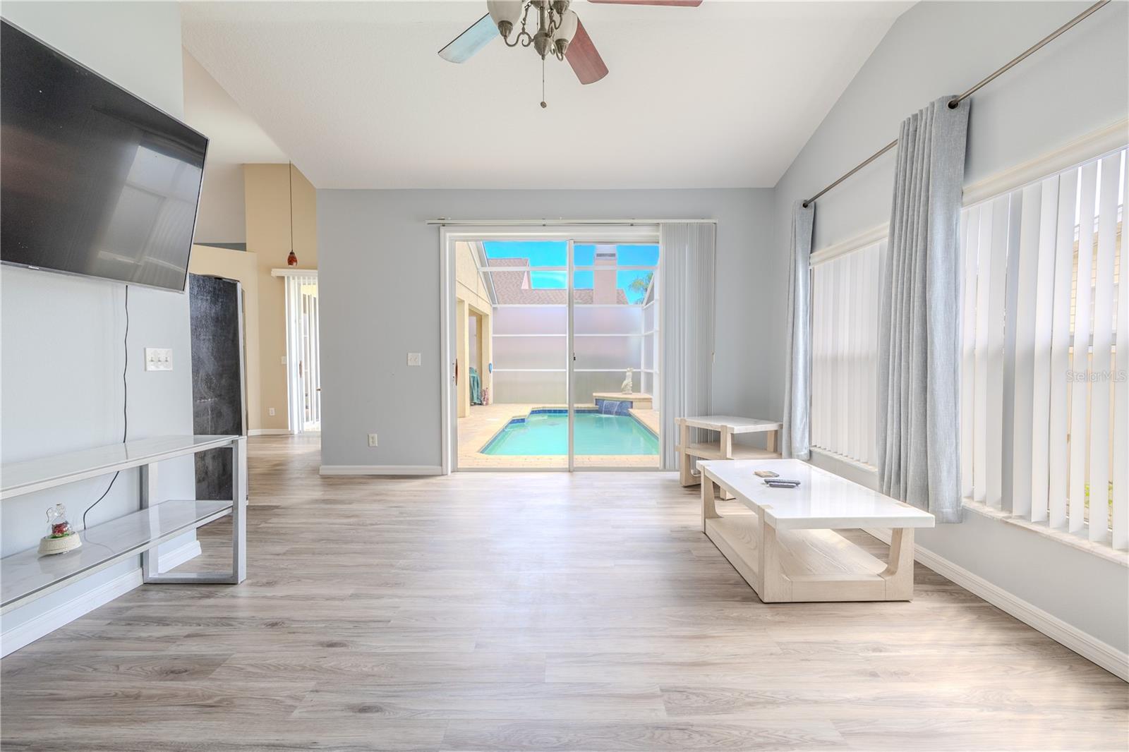 The family room features luxury vinyl flooring and a ceiling fan with light kit.