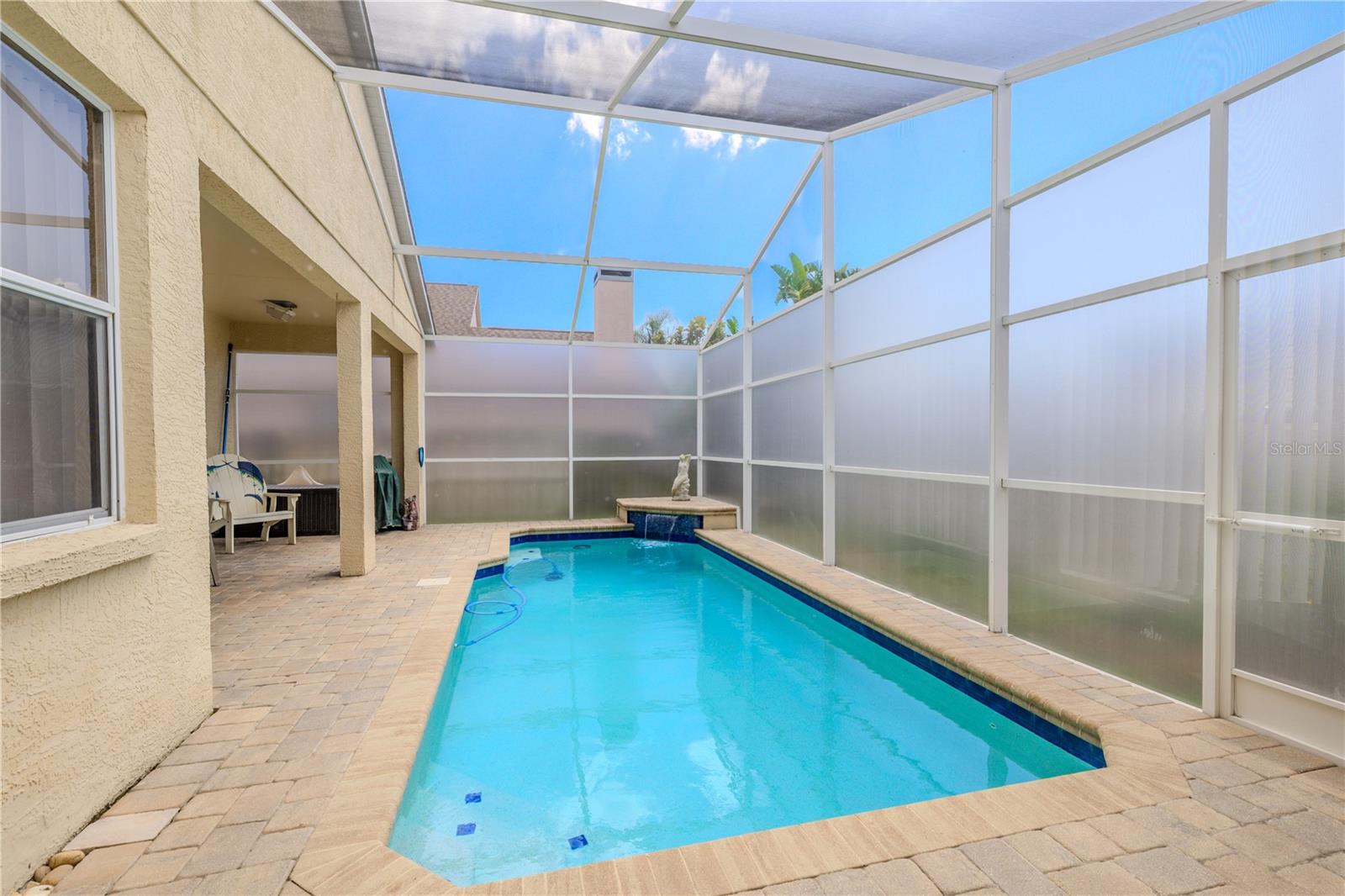 The pool itself is surrounded by privacy panels and features a tranquil water feature, making it feel like a secluded getaway all year long.
