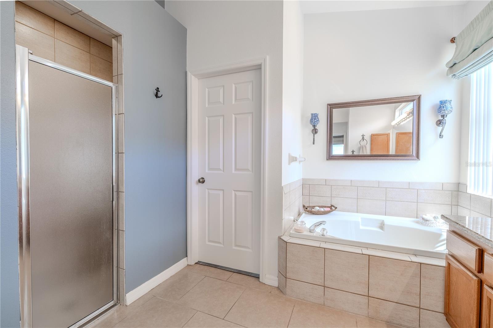 The en-suite bath feels like a personal spa, complete with dual vanities, granite countertops, a garden soaking tub, walk-in shower, private water closet, and plenty of storage.