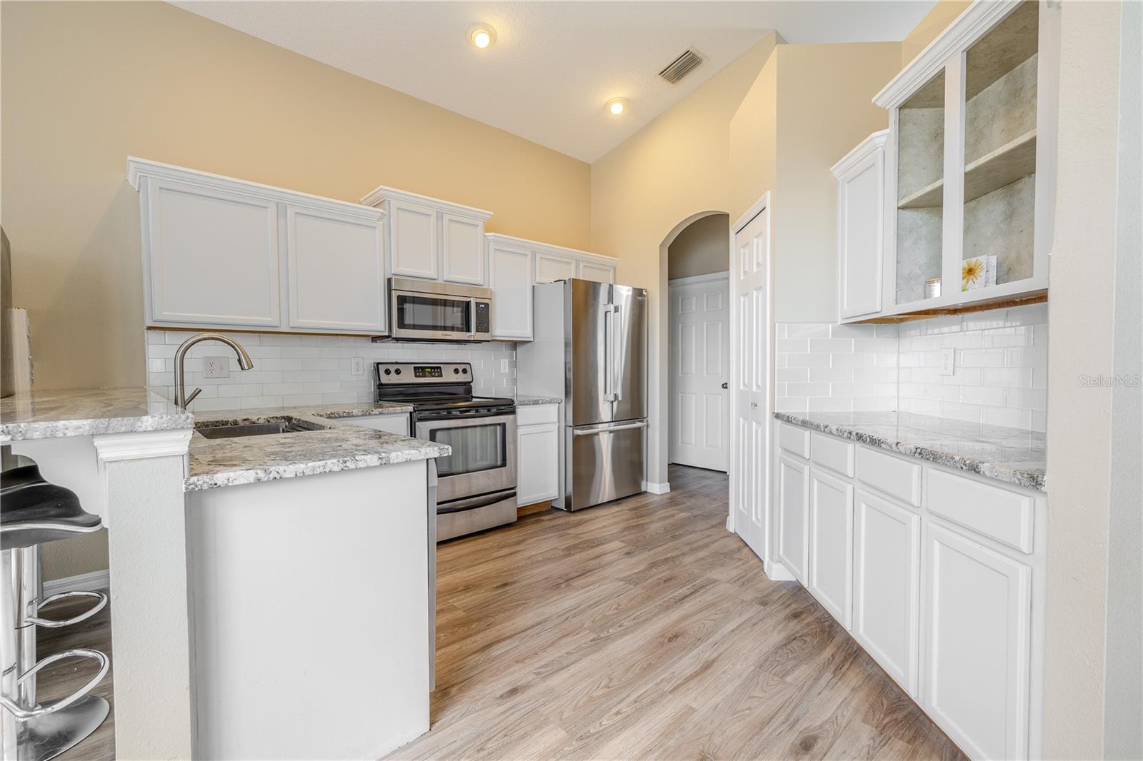 The warm wood cabinetry, granite counters, recessed lighting, and closet pantry bring style and convenience.