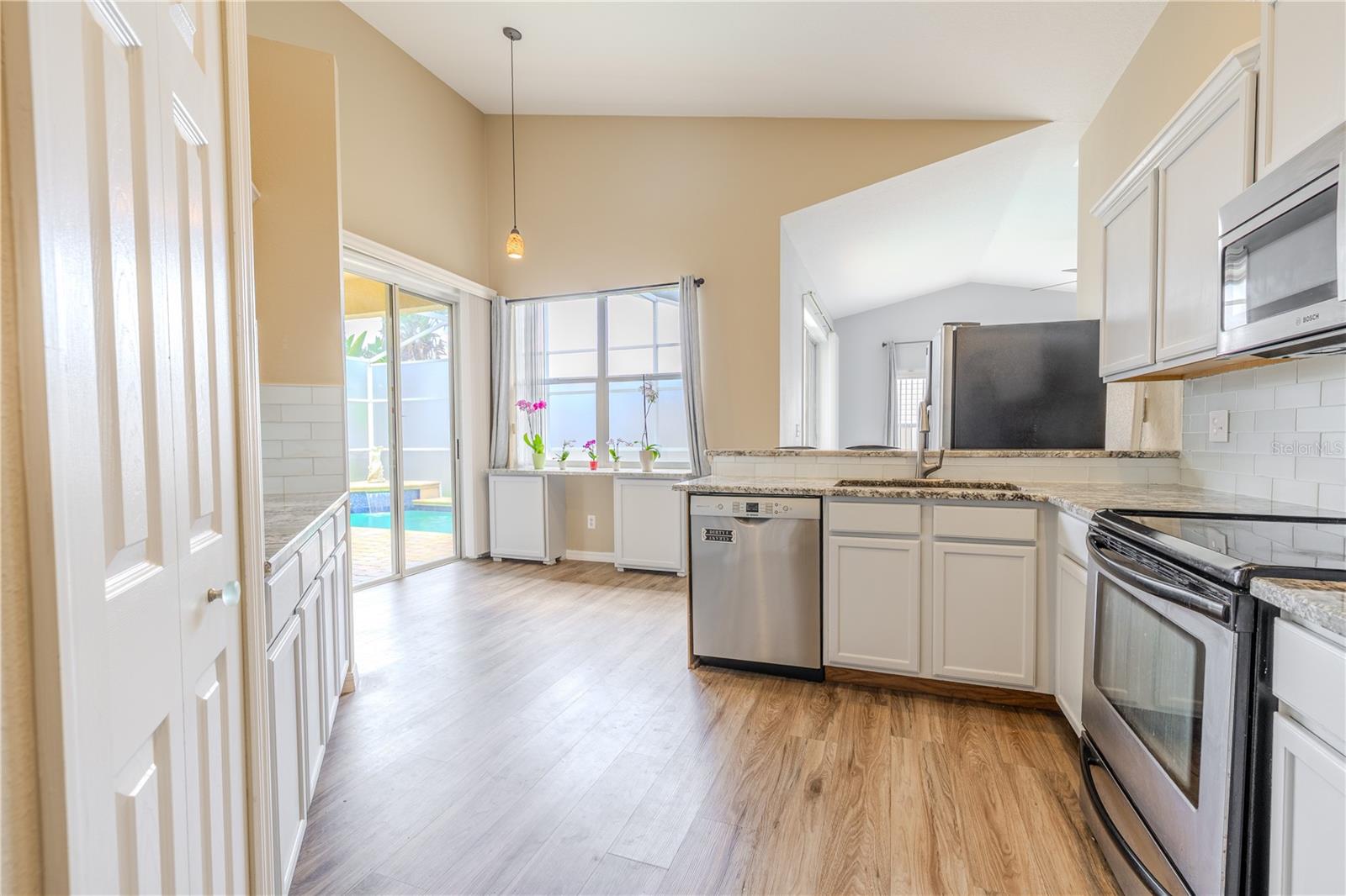 The kitchen ifeatures a full suite of stainless steel appliances including a French door refrigerator, range, microwave, and dishwasher.