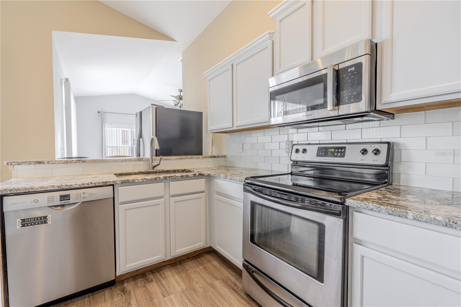Muted tones, granite counters and subway tile backsplash.
