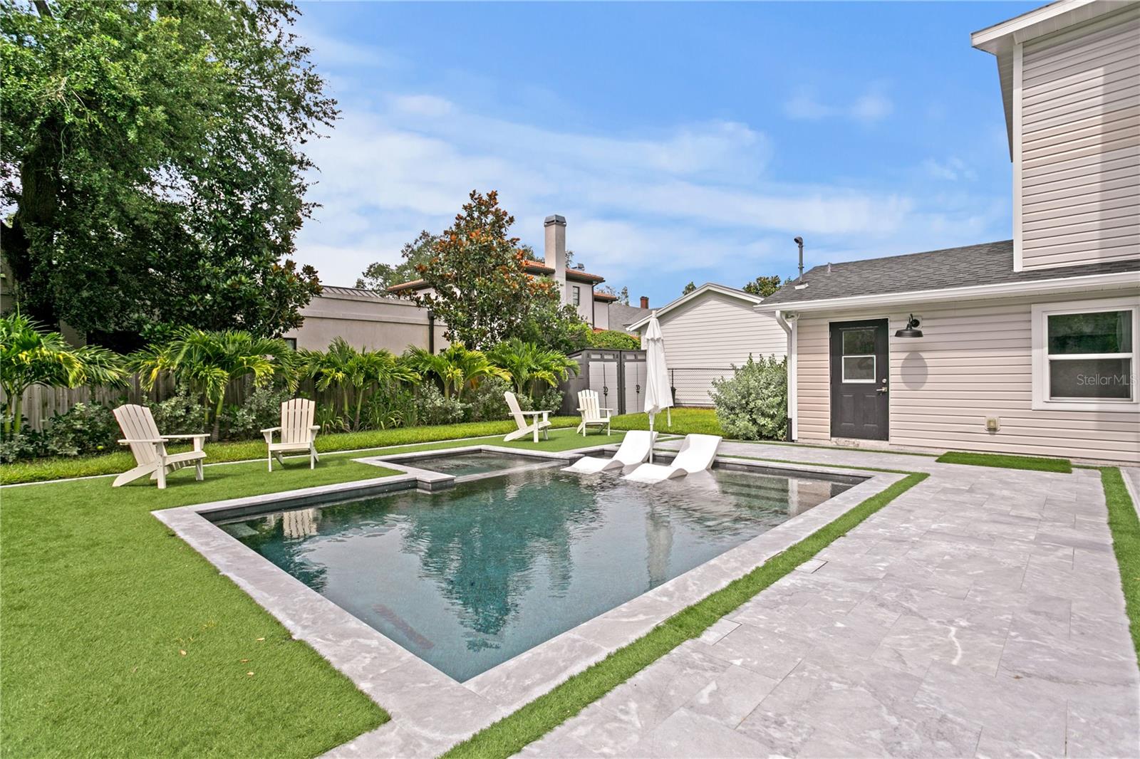 This newly reonvated backyard is complete with a heated saltwater pool and spa, lush turf, & custom lighting