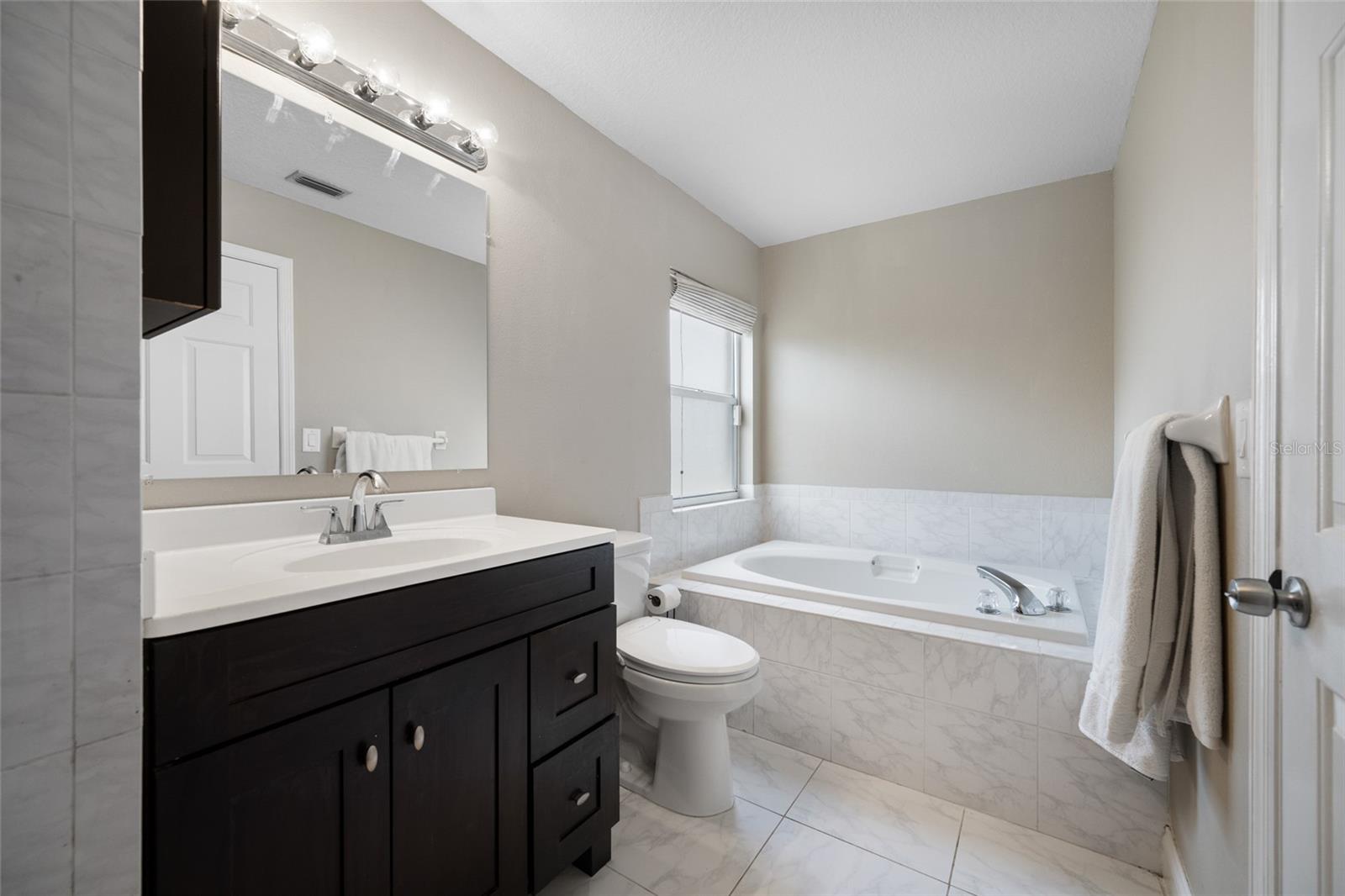 Modern Main Bathroom — 3005 Pepperwood Ln W Features a Bright, Well-Appointed Main Bathroom with Dual Vanities and Ample Storage.