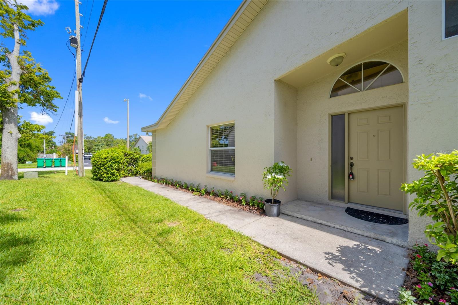 3005 Pepperwood Ln W Welcoming Entry — Elegant Front Door Framed by Lush Landscaping at 3005 Pepperwood Ln W, Clearwater