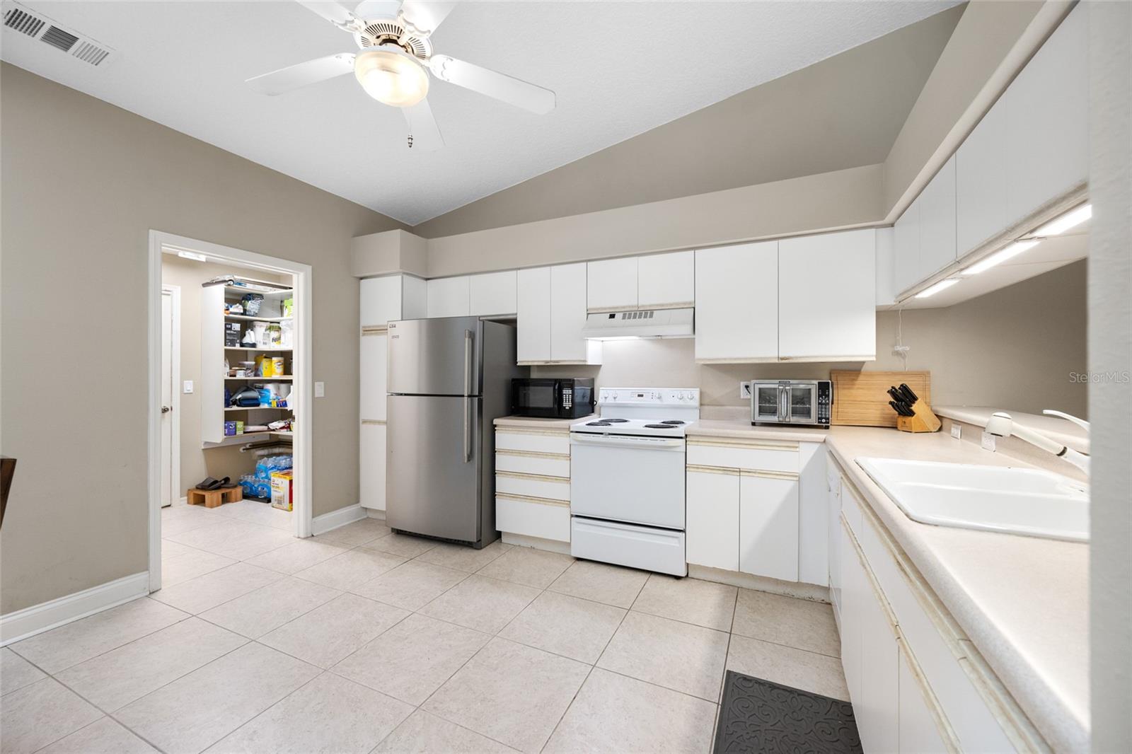 Bright White Kitchen — 3005 Pepperwood Ln W Showcases a Fresh, Modern Kitchen with Crisp White Cabinetry and Ample Natural Light.