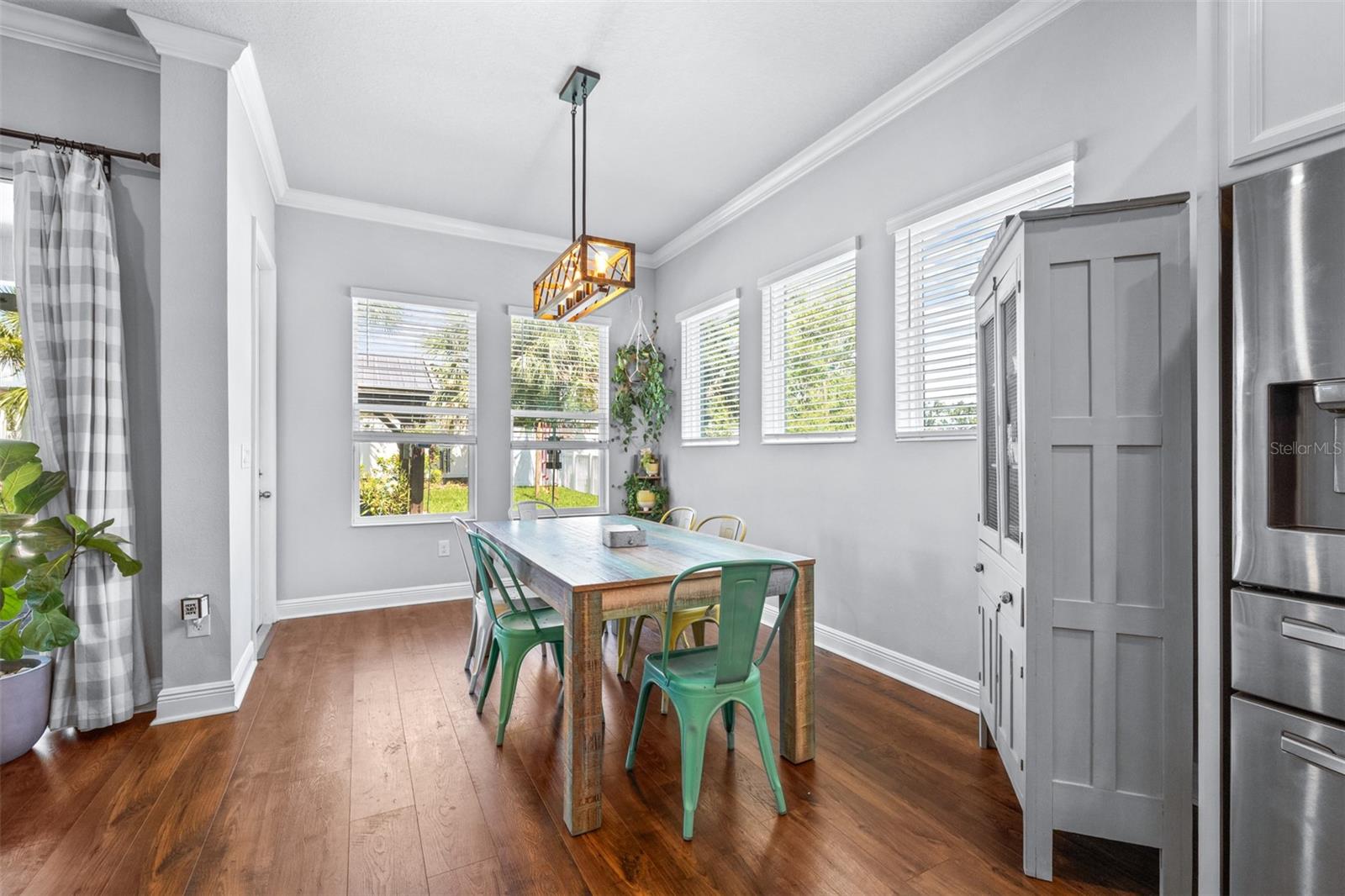 this dining room is bright and light with views of the outdoor yard and greenbelt