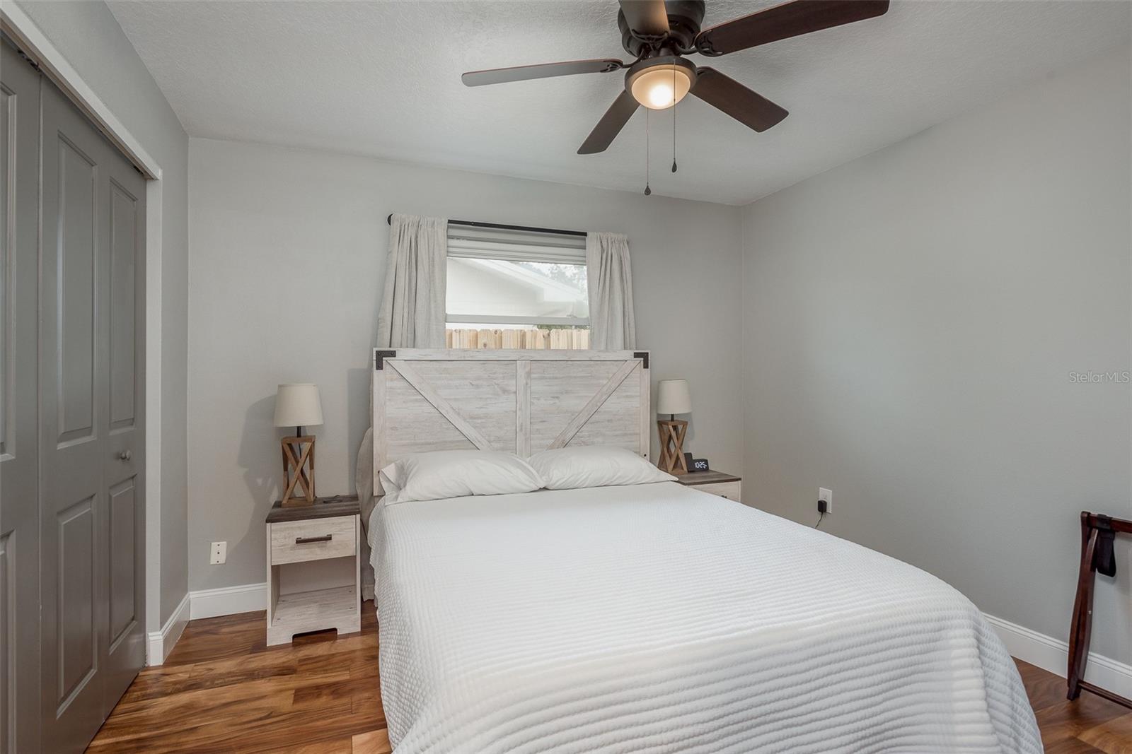 2nd bedroom with queen bed, built in closet and ceiling fan.